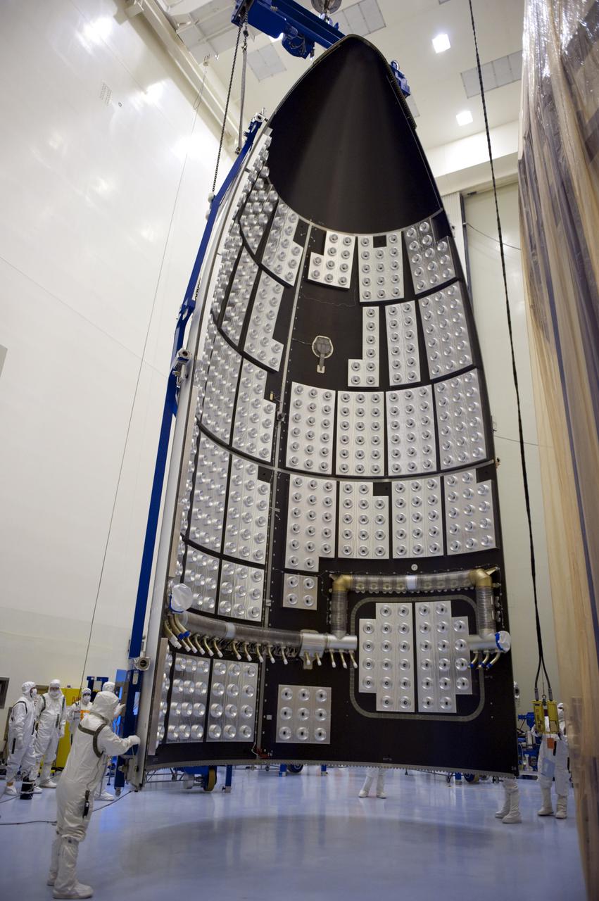 CAPE CANAVERAL, Fla. -- In the Payload Hazardous Servicing Facility at NASA's Kennedy Space Center in Florida, United Launch Alliance technicians steady half of the Atlas V payload fairing for NASA's Mars Science Laboratory (MSL) mission as it hangs vertically from the ceiling. The interior of the fairing is lined with the fairing acoustic protection (FAP) system which protects the payload by dampening the sound created by the rocket during liftoff. As a precaution, the fairing next will be cleaned to meet NASA's planetary protection requirements. The fairing will protect the spacecraft from the impact of aerodynamic pressure and heating during ascent. Although jettisoned once the spacecraft is outside the Earth's atmosphere, the fairing must be cleaned to the same exacting standards as the laboratory to avoid the possibility of contaminating it. MSL's components include a compact car-sized rover, Curiosity, which has 10 science instruments designed to search for evidence on whether Mars has had environments favorable to microbial life, including the chemical ingredients for life. The unique rover will use a laser to look inside rocks and release its gasses so that the rover’s spectrometer can analyze and send the data back to Earth. Launch of MSL aboard a United Launch Alliance Atlas V rocket is planned for Nov. 25 from Space Launch Complex 41 on Cape Canaveral Air Force Station. For more information, visit http:__www.nasa.gov_msl. Photo credit: NASA_Kim Shiflett