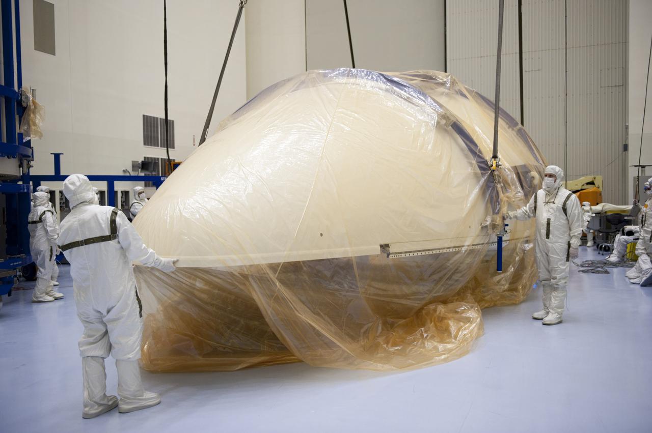 CAPE CANAVERAL, Fla. -- In the Payload Hazardous Servicing Facility at NASA's Kennedy Space Center in Florida, half of the Atlas V payload fairing for NASA's Mars Science Laboratory (MSL) mission comes to rest on the floor in a horizontal position. It next will be uncovered and cleaned to meet NASA's planetary protection requirements. The fairing will protect the spacecraft from the impact of aerodynamic pressure and heating during ascent. Although jettisoned once the spacecraft is outside the Earth's atmosphere, the fairing must be cleaned to the same exacting standards as the laboratory to avoid the possibility of contaminating it. MSL's components include a compact car-sized rover, Curiosity, which has 10 science instruments designed to search for evidence on whether Mars has had environments favorable to microbial life, including the chemical ingredients for life. The unique rover will use a laser to look inside rocks and release its gasses so that the rover’s spectrometer can analyze and send the data back to Earth. Launch of MSL aboard a United Launch Alliance Atlas V rocket is planned for Nov. 25 from Space Launch Complex 41 on Cape Canaveral Air Force Station. For more information, visit http:__www.nasa.gov_msl. Photo credit: NASA_Kim Shiflett