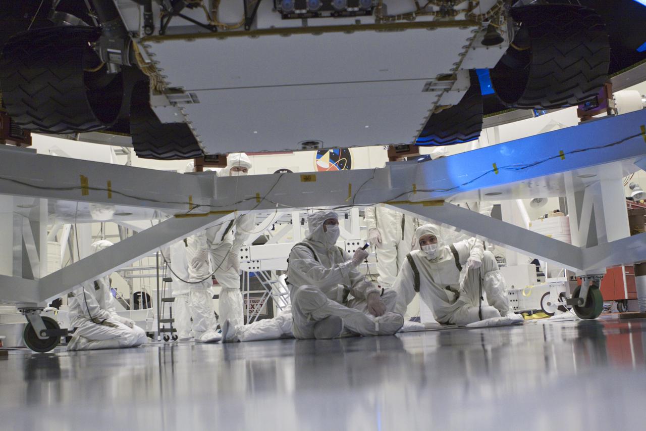 CAPE CANAVERAL, Fla. – In the Payload Hazardous Servicing Facility at NASA’s Kennedy Space Center in Florida, technicians inspect under NASA's Mars Science Laboratory (MSL) mission aeroshell, where the wheels of the rover Curiosity can be seen. MSL's components include a car-sized rover, Curiosity, which has 10 science instruments designed to search for evidence on whether Mars has had environments favorable to microbial life, including chemical ingredients for life. The unique rover will use a laser to look inside rocks and release its gasses so that the rover’s spectrometer can analyze and send the data back to Earth. Launch of MSL aboard a United Launch Alliance Atlas V rocket is scheduled for Nov. 25 from Space Launch Complex 41 on Cape Canaveral Air Force Station in Florida. For more information, visit http:__www.nasa.gov_msl. Photo credit: NASA_Glenn Benson