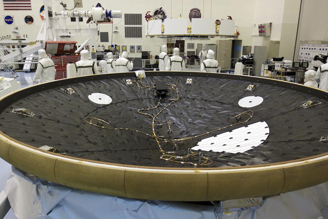 CAPE CANAVERAL, Fla. – In the Payload Hazardous Servicing Facility at NASA’s Kennedy Space Center in Florida, technicians, using an overhead crane, lift NASA's Mars Science Laboratory (MSL) mission cruise stage for placement onto a rotation stand. The cruise stage provides solar power, thrusters for navigation, and heat exchangers to the rover during its flight from Earth to Mars. In the foreground is the heat shield for MSL. MSL's components include a car-sized rover, Curiosity, which has 10 science instruments designed to search for evidence on whether Mars has had environments favorable to microbial life, including chemical ingredients for life. The unique rover will use a laser to look inside rocks and release its gasses so that the rover’s spectrometer can analyze and send the data back to Earth. Launch of MSL aboard a United Launch Alliance Atlas V rocket is scheduled for Nov. 25 from Space Launch Complex 41 on Cape Canaveral Air Force Station in Florida. For more information, visit http:__www.nasa.gov_msl. Photo credit: NASA_Glenn Benson
