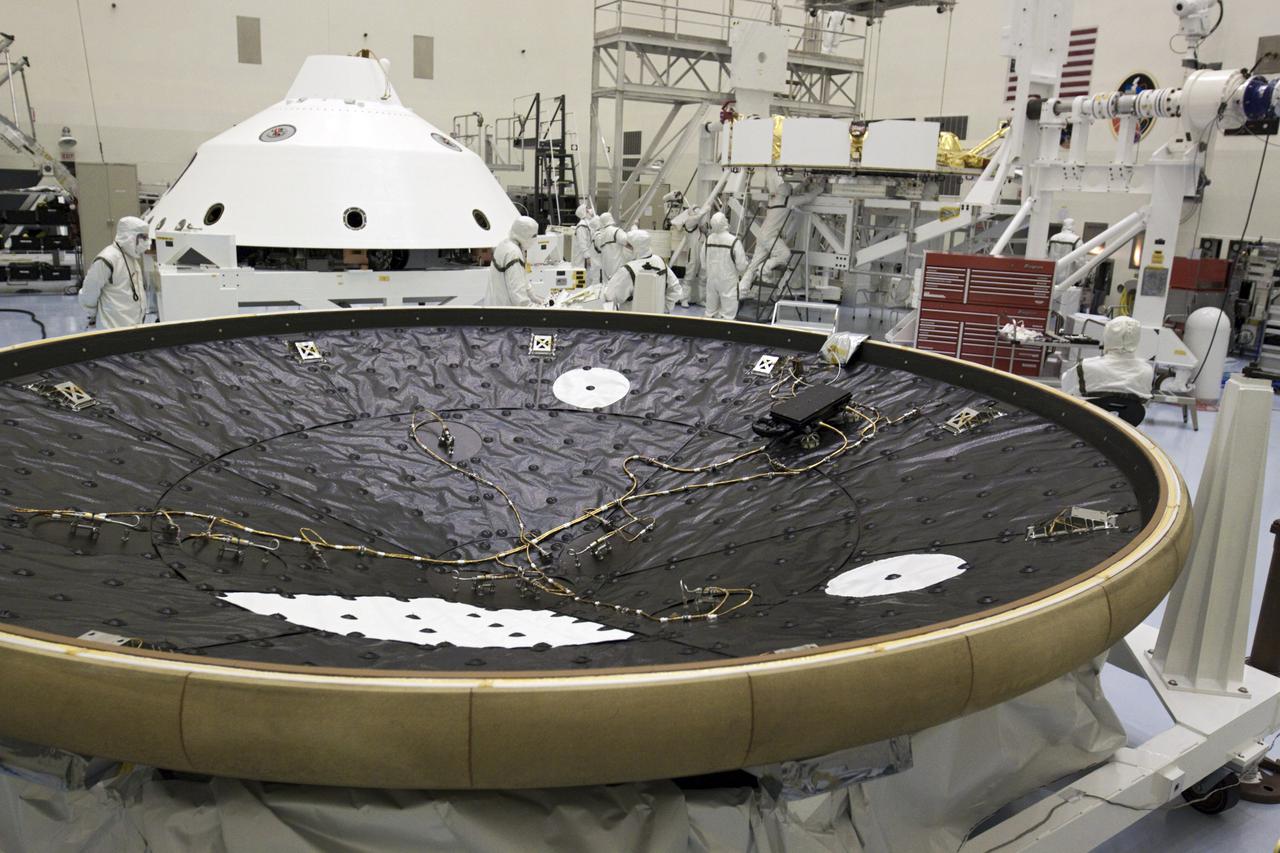 CAPE CANAVERAL, Fla. – In the Payload Hazardous Servicing Facility at NASA’s Kennedy Space Center in Florida, technicians inspect NASA's Mars Science Laboratory (MSL) mission cruise stage as it is guided onto a rotation stand. The cruise stage provides solar power, thrusters for navigation, and heat exchangers to the rover during its flight from Earth to Mars. In the foreground is the MSL heat shield and to the left, the aeroshell. MSL's components include a car-sized rover, Curiosity, which has 10 science instruments designed to search for evidence on whether Mars has had environments favorable to microbial life, including chemical ingredients for life. The unique rover will use a laser to look inside rocks and release its gasses so that the rover’s spectrometer can analyze and send the data back to Earth. Launch of MSL aboard a United Launch Alliance Atlas V rocket is scheduled for Nov. 25 from Space Launch Complex 41 on Cape Canaveral Air Force Station in Florida. For more information, visit http:__www.nasa.gov_msl. Photo credit: NASA_Glenn Benson