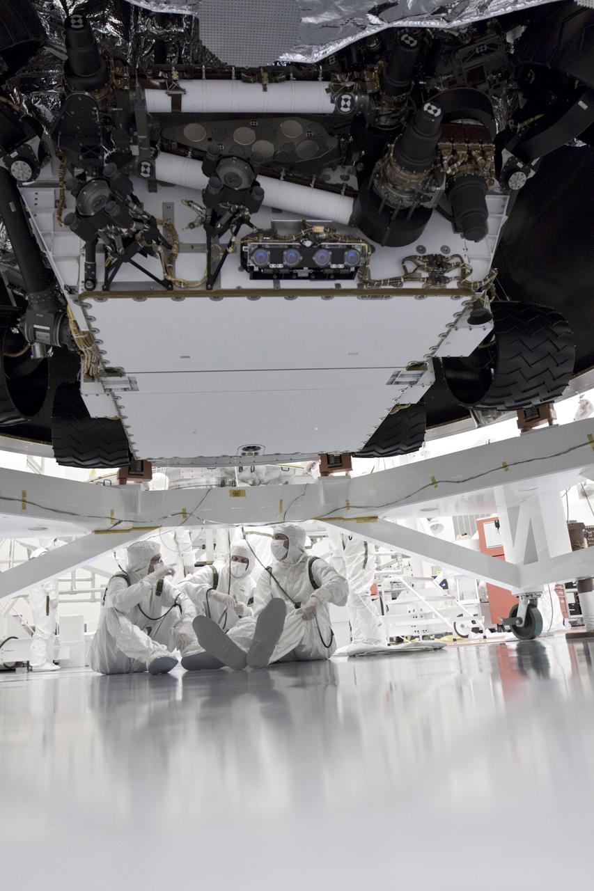 CAPE CANAVERAL, Fla. – In the Payload Hazardous Servicing Facility at NASA’s Kennedy Space Center in Florida, technicians consult with one another under NASA's Mars Science Laboratory (MSL) mission aeroshell, where the wheels of the rover Curiosity can be seen. MSL's components include a car-sized rover, Curiosity, which has 10 science instruments designed to search for evidence on whether Mars has had environments favorable to microbial life, including chemical ingredients for life. The unique rover will use a laser to look inside rocks and release its gasses so that the rover’s spectrometer can analyze and send the data back to Earth. Launch of MSL aboard a United Launch Alliance Atlas V rocket is scheduled for Nov. 25 from Space Launch Complex 41 on Cape Canaveral Air Force Station in Florida. For more information, visit http:__www.nasa.gov_msl. Photo credit: NASA_Glenn Benson
