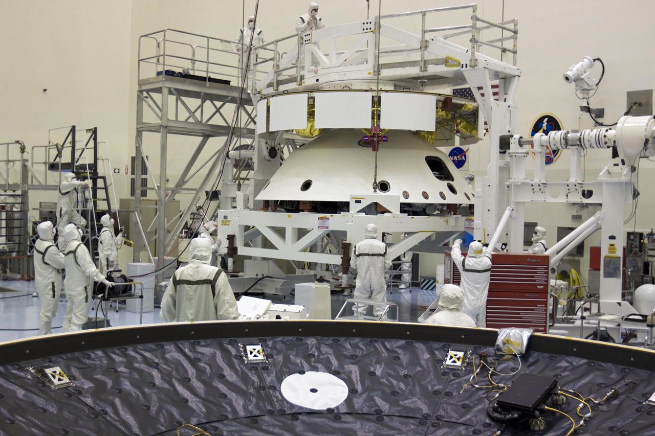 CAPE CANAVERAL, Fla. – In the Payload Hazardous Servicing Facility at NASA’s Kennedy Space Center in Florida, technicians, using an overhead crane, lift NASA's Mars Science Laboratory (MSL) mission aeroshell, (containing the compact car-sized rover Curiosity), for mating to the cruise stage. The cruise stage provides solar power, thrusters for navigation, and heat exchangers to the rover during its flight from Earth to Mars. In the foreground is the MSL heat shield.  The rover Curiosity has 10 science instruments designed to search for evidence on whether Mars has had environments favorable to microbial life, including chemical ingredients for life.  The unique rover will use a laser to look inside rocks and release its gasses so that the rover’s spectrometer can analyze and send the data back to Earth. Launch of MSL aboard a United Launch Alliance Atlas V rocket is scheduled for Nov. 25 from Space Launch Complex 41 on Cape Canaveral Air Force Station in Florida. For more information, visit http:__www.nasa.gov_msl. Photo credit: NASA_Glenn Benson