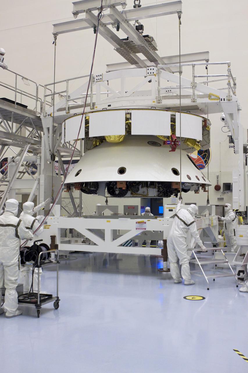 CAPE CANAVERAL, Fla. – In the Payload Hazardous Servicing Facility at NASA’s Kennedy Space Center in Florida, technicians, using an overhead crane, lift NASA's Mars Science Laboratory (MSL) mission aeroshell, (containing the compact car-sized rover Curiosity), for mating to the cruise stage. The cruise stage provides solar power, thrusters for navigation, and heat exchangers to the rover during its flight from Earth to Mars. The rover Curiosity has 10 science instruments designed to search for evidence on whether Mars has had environments favorable to microbial life, including chemical ingredients for life. The unique rover will use a laser to look inside rocks and release its gasses so that the rover’s spectrometer can analyze and send the data back to Earth. Launch of MSL aboard a United Launch Alliance Atlas V rocket is scheduled for Nov. 25 from Space Launch Complex 41 on Cape Canaveral Air Force Station in Florida. For more information, visit http:__www.nasa.gov_msl. Photo credit: NASA_Glenn Benson