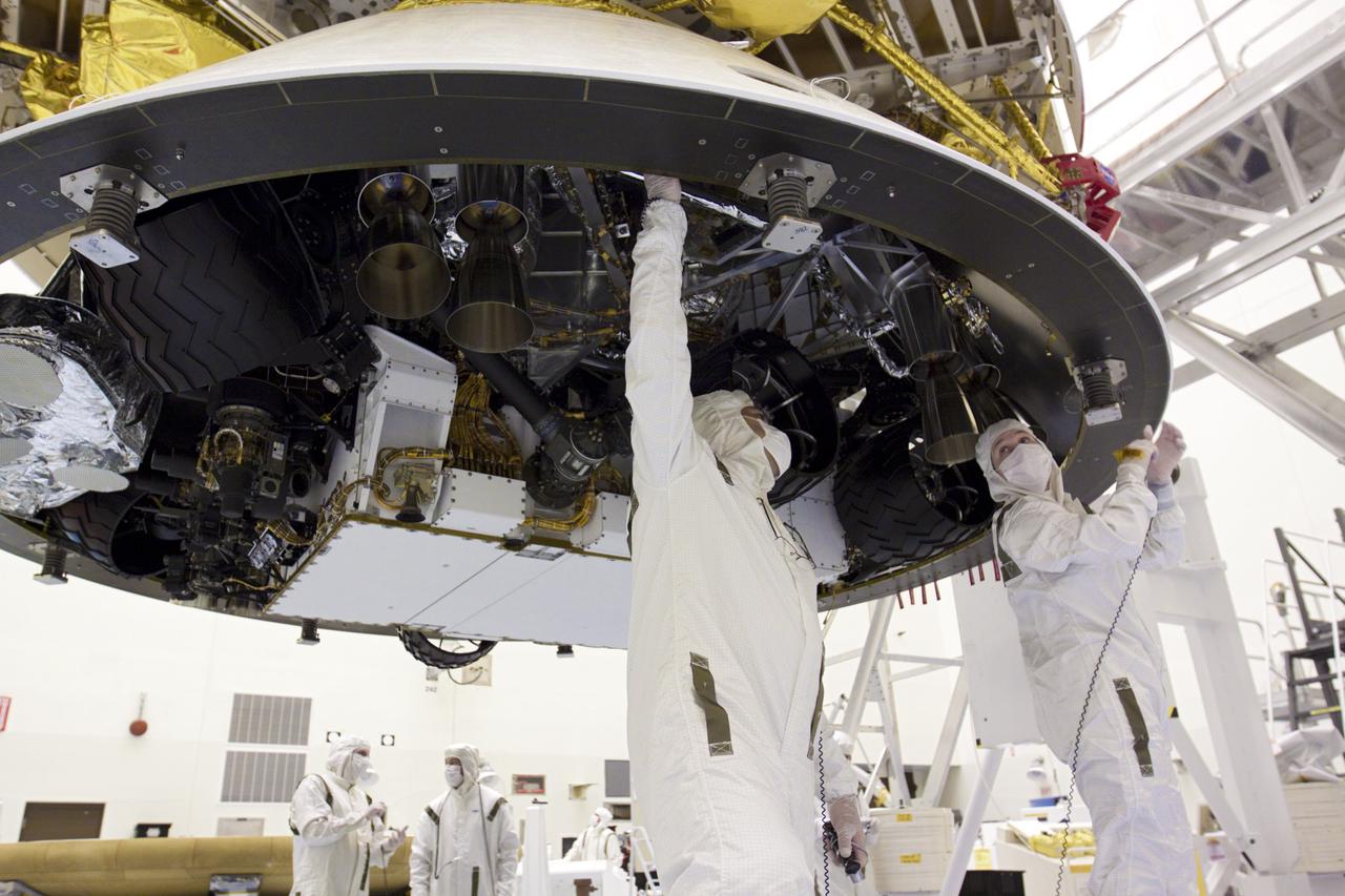 CAPE CANAVERAL, Fla. – In the Payload Hazardous Servicing Facility at NASA’s Kennedy Space Center in Florida, technicians work beneath NASA's Mars Science Laboratory (MSL) mission aeroshell, (containing the compact car-sized rover Curiosity), which has been mated to the cruise stage. The cruise stage provides solar power, thrusters for navigation, and heat exchangers to the rover during its flight from Earth to Mars. The rover Curiosity has 10 science instruments designed to search for evidence on whether Mars has had environments favorable to microbial life, including chemical ingredients for life. The unique rover will use a laser to look inside rocks and release its gasses so that the rover’s spectrometer can analyze and send the data back to Earth. Launch of MSL aboard a United Launch Alliance Atlas V rocket is scheduled for Nov. 25 from Space Launch Complex 41 on Cape Canaveral Air Force Station in Florida. For more information, visit http:__www.nasa.gov_msl. Photo credit: NASA_Glenn Benson