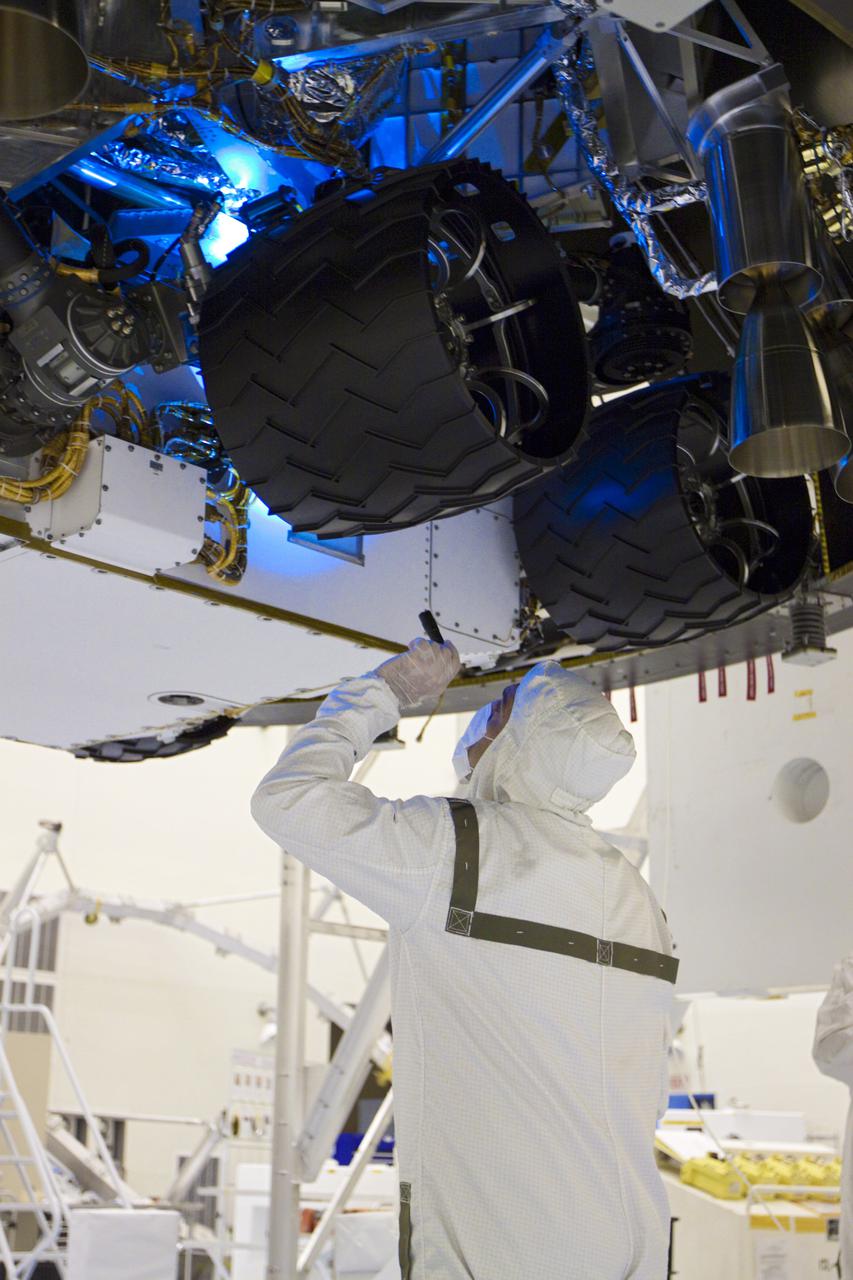 CAPE CANAVERAL, Fla. – In the Payload Hazardous Servicing Facility at NASA’s Kennedy Space Center in Florida, a technician inspects beneath NASA's Mars Science Laboratory (MSL) mission aeroshell, (containing the compact car-sized rover Curiosity), which has been mated to the cruise stage. The cruise stage provides solar power, thrusters for navigation, and heat exchangers to the rover during its flight from Earth to Mars. The rover Curiosity has 10 science instruments designed to search for evidence on whether Mars has had environments favorable to microbial life, including chemical ingredients for life. The unique rover will use a laser to look inside rocks and release its gasses so that the rover’s spectrometer can analyze and send the data back to Earth. Launch of MSL aboard a United Launch Alliance Atlas V rocket is scheduled for Nov. 25 from Space Launch Complex 41 on Cape Canaveral Air Force Station in Florida. For more information, visit http:__www.nasa.gov_msl. Photo credit: NASA_Glenn Benson