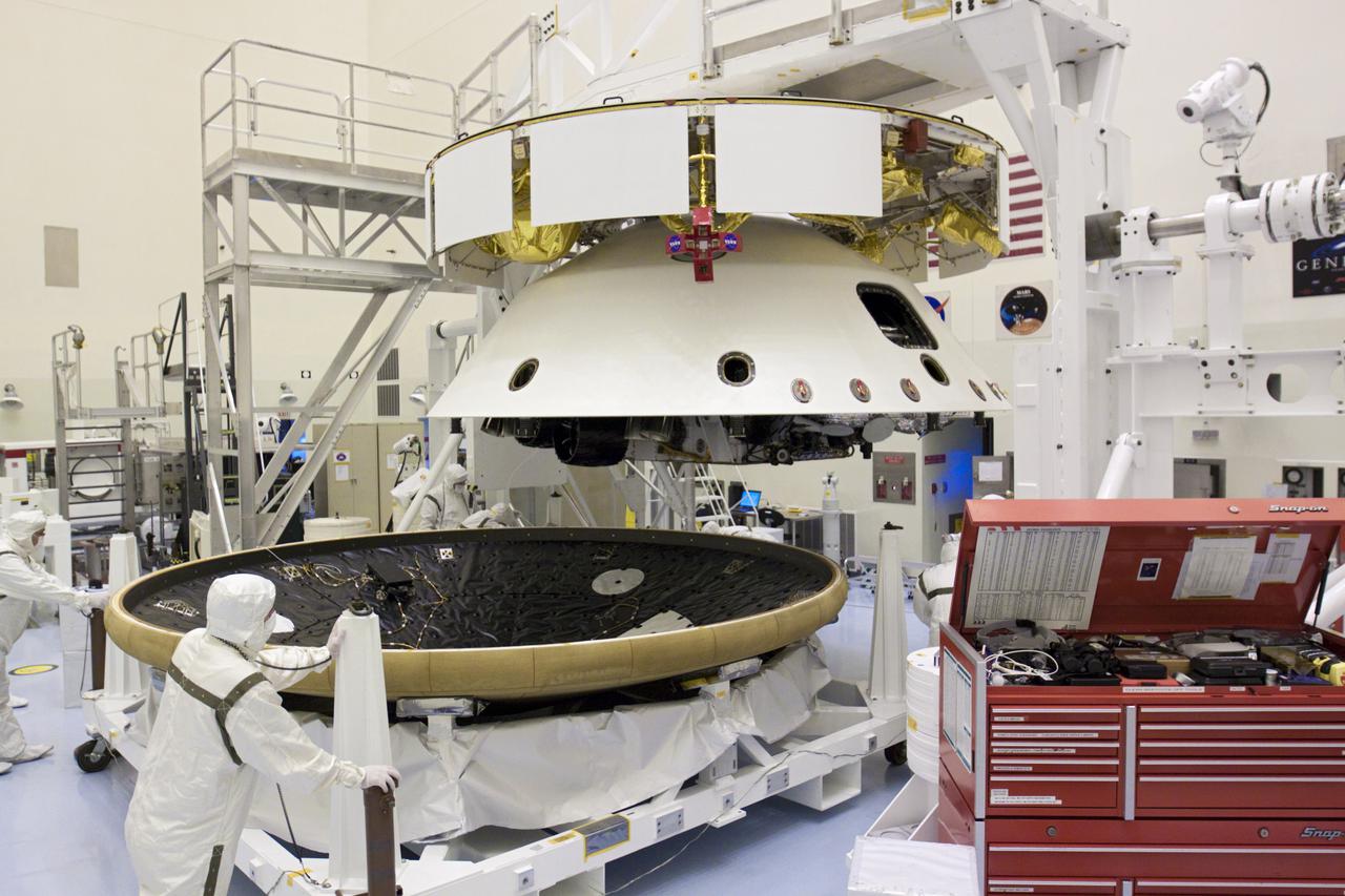 CAPE CANAVERAL, Fla. – In the Payload Hazardous Servicing Facility at NASA’s Kennedy Space Center in Florida, technicians roll the heat shield beneath NASA's Mars Science Laboratory (MSL) mission aeroshell, (containing the compact car-sized rover Curiosity), for integration. Earlier, the aeroshell was mated to the cruise stage, which provides solar power, thrusters for navigation, and heat exchangers to the rover during its flight from Earth to Mars. The rover Curiosity has 10 science instruments designed to search for evidence on whether Mars has had environments favorable to microbial life, including chemical ingredients for life. The unique rover will use a laser to look inside rocks and release its gasses so that the rover’s spectrometer can analyze and send the data back to Earth. Launch of MSL aboard a United Launch Alliance Atlas V rocket is scheduled for Nov. 25 from Space Launch Complex 41 on Cape Canaveral Air Force Station in Florida. For more information, visit http:__www.nasa.gov_msl. Photo credit: NASA_Glenn Benson
