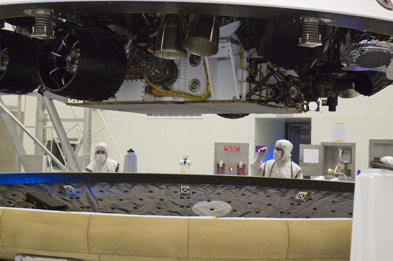 CAPE CANAVERAL, Fla. – In the Payload Hazardous Servicing Facility at NASA’s Kennedy Space Center in Florida, technicians inspect the heat shield in preparation for integration with NASA's Mars Science Laboratory (MSL) mission aeroshell, (containing the compact car-sized rover Curiosity). Earlier, the aeroshell was mated to the cruise stage, which provides solar power, thrusters for navigation, and heat exchangers to the rover during its flight from Earth to Mars. The rover Curiosity has 10 science instruments designed to search for evidence on whether Mars has had environments favorable to microbial life, including chemical ingredients for life. The unique rover will use a laser to look inside rocks and release its gasses so that the rover’s spectrometer can analyze and send the data back to Earth. Launch of MSL aboard a United Launch Alliance Atlas V rocket is scheduled for Nov. 25 from Space Launch Complex 41 on Cape Canaveral Air Force Station in Florida. For more information, visit http:__www.nasa.gov_msl. Photo credit: NASA_Glenn Benson