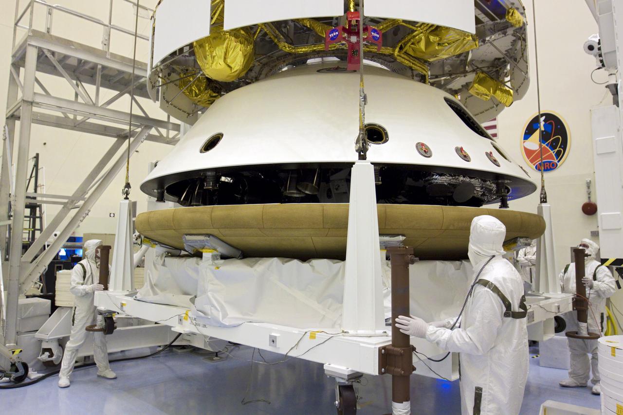 CAPE CANAVERAL, Fla. – In the Payload Hazardous Servicing Facility at NASA’s Kennedy Space Center in Florida, under the watchful eyes of technicians, an overhead crane lifts the heat shield for integration with NASA's Mars Science Laboratory (MSL) mission aeroshell, (containing the compact car-sized rover Curiosity). Earlier, the aeroshell was mated to the cruise stage, which provides solar power, thrusters for navigation, and heat exchangers to the rover during its flight from Earth to Mars. The rover Curiosity has 10 science instruments designed to search for evidence on whether Mars has had environments favorable to microbial life, including chemical ingredients for life. The unique rover will use a laser to look inside rocks and release its gasses so that the rover’s spectrometer can analyze and send the data back to Earth. Launch of MSL aboard a United Launch Alliance Atlas V rocket is scheduled for Nov. 25 from Space Launch Complex 41 on Cape Canaveral Air Force Station in Florida. For more information, visit http:__www.nasa.gov_msl. Photo credit: NASA_Glenn Benson