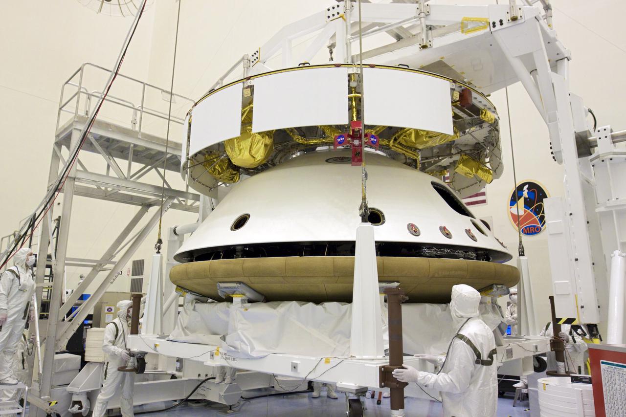 CAPE CANAVERAL, Fla. – In the Payload Hazardous Servicing Facility at NASA’s Kennedy Space Center in Florida, under the watchful eyes of technicians, an overhead crane lifts the heat shield for integration with NASA's Mars Science Laboratory (MSL) mission aeroshell, (containing the compact car-sized rover Curiosity). Earlier, the aeroshell was mated to the cruise stage, which provides solar power, thrusters for navigation, and heat exchangers to the rover during its flight from Earth to Mars. The rover Curiosity has 10 science instruments designed to search for evidence on whether Mars has had environments favorable to microbial life, including chemical ingredients for life. The unique rover will use a laser to look inside rocks and release its gasses so that the rover’s spectrometer can analyze and send the data back to Earth. Launch of MSL aboard a United Launch Alliance Atlas V rocket is scheduled for Nov. 25 from Space Launch Complex 41 on Cape Canaveral Air Force Station in Florida. For more information, visit http:__www.nasa.gov_msl. Photo credit: NASA_Glenn Benson