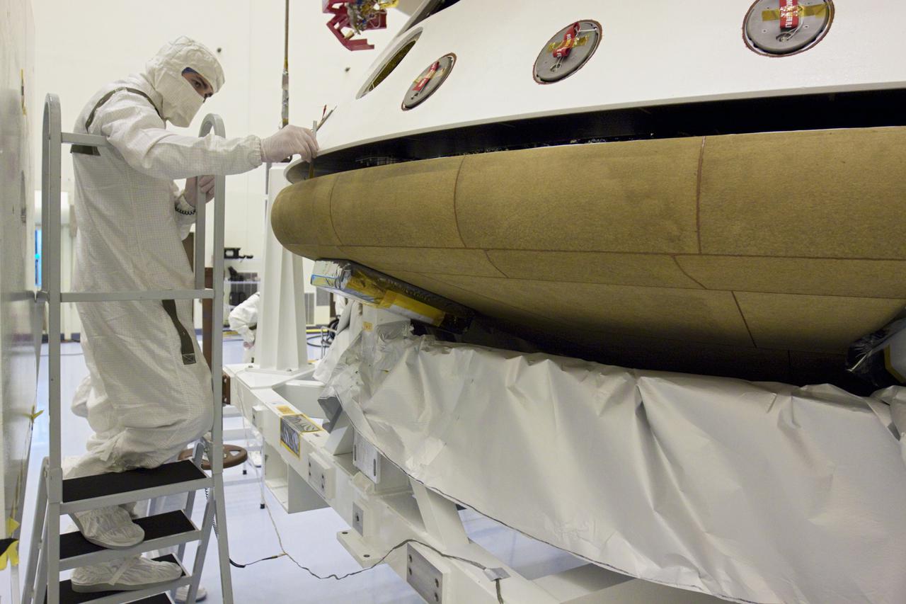 CAPE CANAVERAL, Fla. – In the Payload Hazardous Servicing Facility at NASA’s Kennedy Space Center in Florida, a technician inspects the alignment of the heat shield as an overhead crane lifts it for integration with NASA's Mars Science Laboratory (MSL) mission aeroshell, (containing the compact car-sized rover Curiosity). Earlier, the aeroshell was mated to the cruise stage, which provides solar power, thrusters for navigation, and heat exchangers to the rover during its flight from Earth to Mars. The rover Curiosity has 10 science instruments designed to search for evidence on whether Mars has had environments favorable to microbial life, including chemical ingredients for life. The unique rover will use a laser to look inside rocks and release its gasses so that the rover’s spectrometer can analyze and send the data back to Earth. Launch of MSL aboard a United Launch Alliance Atlas V rocket is scheduled for Nov. 25 from Space Launch Complex 41 on Cape Canaveral Air Force Station in Florida. For more information, visit http:__www.nasa.gov_msl. Photo credit: NASA_Glenn Benson