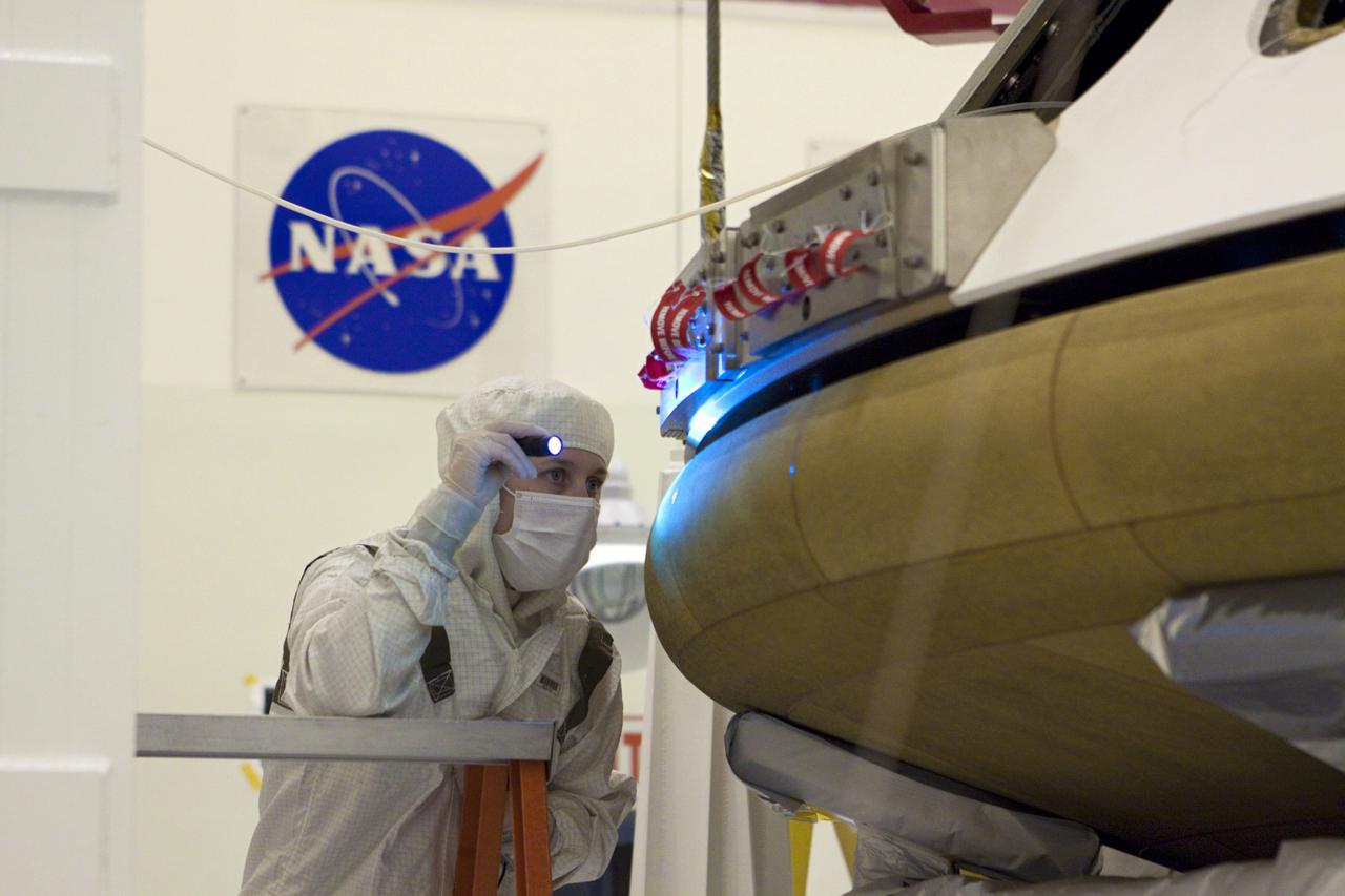 CAPE CANAVERAL, Fla. – In the Payload Hazardous Servicing Facility at NASA’s Kennedy Space Center in Florida, a technician inspects the alignment of the heat shield as an overhead crane lifts it for integration with NASA's Mars Science Laboratory (MSL) mission aeroshell, (containing the compact car-sized rover Curiosity). Earlier, the aeroshell was mated to the cruise stage, which provides solar power, thrusters for navigation, and heat exchangers to the rover during its flight from Earth to Mars. The rover Curiosity has 10 science instruments designed to search for evidence on whether Mars has had environments favorable to microbial life, including chemical ingredients for life. The unique rover will use a laser to look inside rocks and release its gasses so that the rover’s spectrometer can analyze and send the data back to Earth. Launch of MSL aboard a United Launch Alliance Atlas V rocket is scheduled for Nov. 25 from Space Launch Complex 41 on Cape Canaveral Air Force Station in Florida. For more information, visit http:__www.nasa.gov_msl. Photo credit: NASA_Glenn Benson