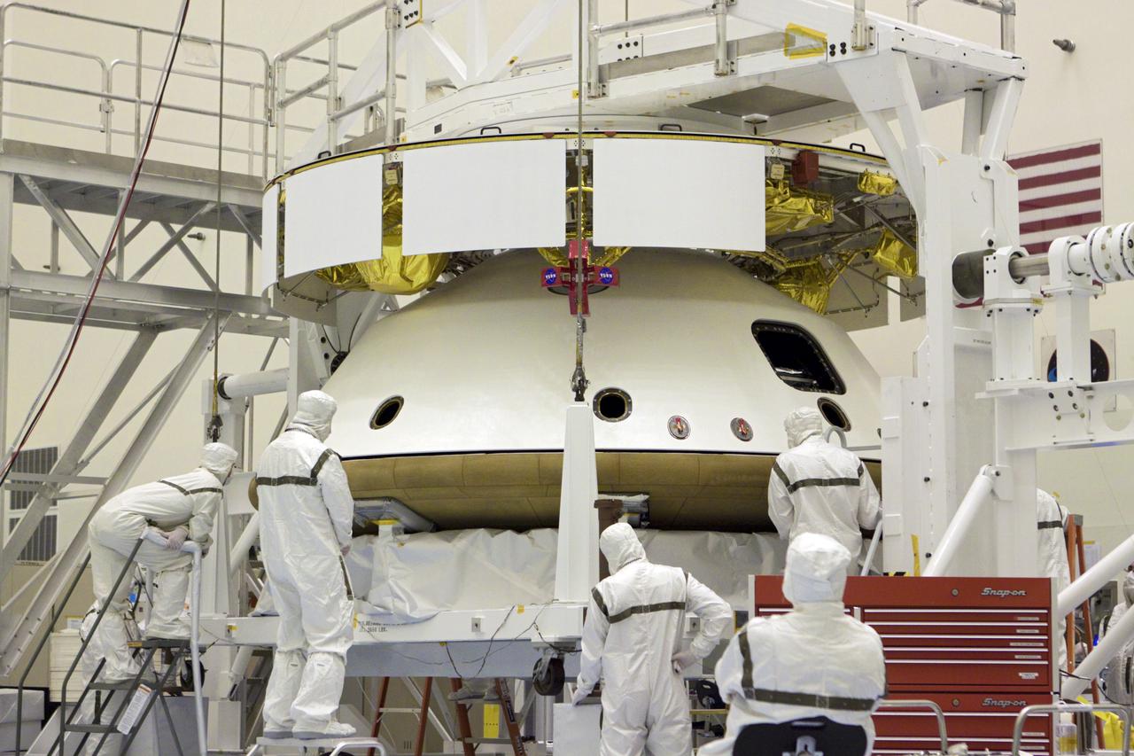 CAPE CANAVERAL, Fla. – In the Payload Hazardous Servicing Facility at NASA’s Kennedy Space Center in Florida, technicians monitor the alignment of the heat shield as an overhead crane lifts it for integration with NASA's Mars Science Laboratory (MSL) mission aeroshell, (containing the compact car-sized rover Curiosity). Earlier, the aeroshell was mated to the cruise stage, which provides solar power, thrusters for navigation, and heat exchangers to the rover during its flight from Earth to Mars. The rover Curiosity has 10 science instruments designed to search for evidence on whether Mars has had environments favorable to microbial life, including chemical ingredients for life. The unique rover will use a laser to look inside rocks and release its gasses so that the rover’s spectrometer can analyze and send the data back to Earth. Launch of MSL aboard a United Launch Alliance Atlas V rocket is scheduled for Nov. 25 from Space Launch Complex 41 on Cape Canaveral Air Force Station in Florida. For more information, visit http:__www.nasa.gov_msl. Photo credit: NASA_Glenn Benson