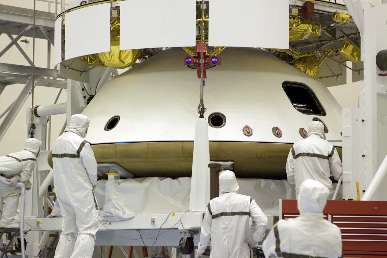 CAPE CANAVERAL, Fla. – In the Payload Hazardous Servicing Facility at NASA’s Kennedy Space Center in Florida, technicians monitor the alignment of the heat shield as an overhead crane lifts it for integration with NASA's Mars Science Laboratory (MSL) mission aeroshell, (containing the compact car-sized rover Curiosity). Earlier, the aeroshell was mated to the cruise stage, which provides solar power, thrusters for navigation, and heat exchangers to the rover during its flight from Earth to Mars. The rover Curiosity has 10 science instruments designed to search for evidence on whether Mars has had environments favorable to microbial life, including chemical ingredients for life. The unique rover will use a laser to look inside rocks and release its gasses so that the rover’s spectrometer can analyze and send the data back to Earth. Launch of MSL aboard a United Launch Alliance Atlas V rocket is scheduled for Nov. 25 from Space Launch Complex 41 on Cape Canaveral Air Force Station in Florida. For more information, visit http:__www.nasa.gov_msl. Photo credit: NASA_Glenn Benson