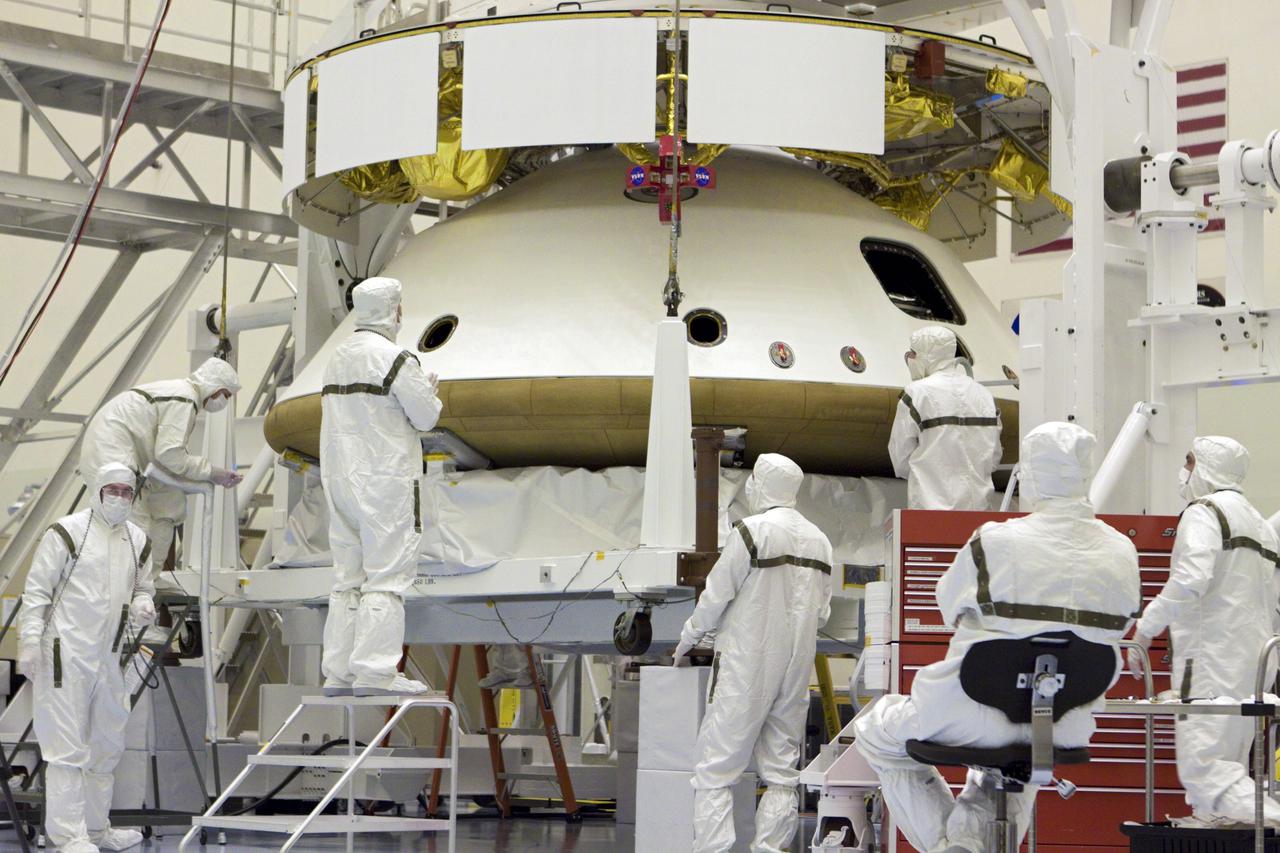 CAPE CANAVERAL, Fla. – In the Payload Hazardous Servicing Facility at NASA’s Kennedy Space Center in Florida, technicians monitor the alignment of the heat shield as an overhead crane lifts it for integration with NASA's Mars Science Laboratory (MSL) mission aeroshell, (containing the compact car-sized rover Curiosity). Earlier, the aeroshell was mated to the cruise stage, which provides solar power, thrusters for navigation, and heat exchangers to the rover during its flight from Earth to Mars. The rover Curiosity has 10 science instruments designed to search for evidence on whether Mars has had environments favorable to microbial life, including chemical ingredients for life. The unique rover will use a laser to look inside rocks and release its gasses so that the rover’s spectrometer can analyze and send the data back to Earth. Launch of MSL aboard a United Launch Alliance Atlas V rocket is scheduled for Nov. 25 from Space Launch Complex 41 on Cape Canaveral Air Force Station in Florida. For more information, visit http:__www.nasa.gov_msl. Photo credit: NASA_Glenn Benson