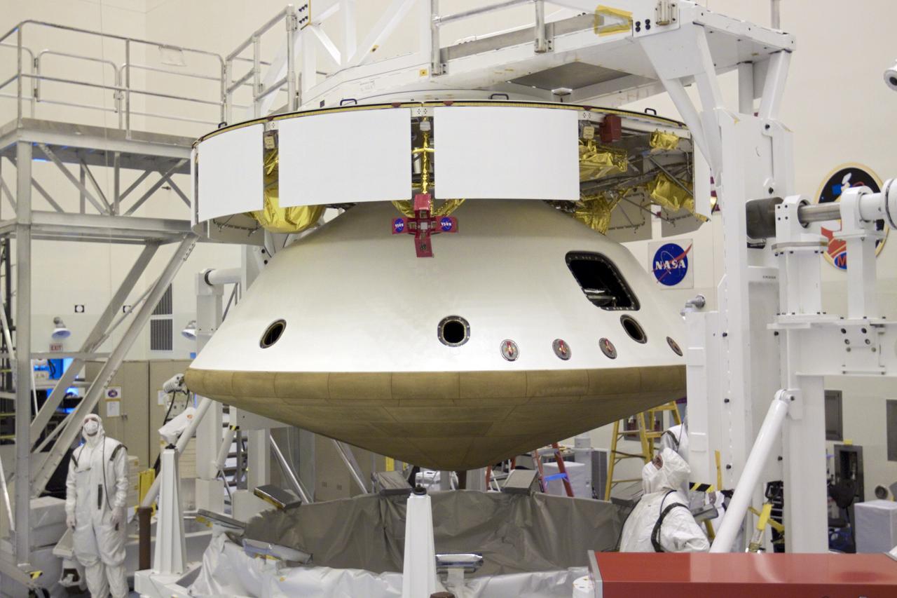 CAPE CANAVERAL, Fla. – In the Payload Hazardous Servicing Facility at NASA’s Kennedy Space Center in Florida, technicians observe the raising of an overhead crane. The crane was used to integrate the heat shield with NASA's Mars Science Laboratory (MSL) mission aeroshell, (containing the compact car-sized rover Curiosity). Earlier, the aeroshell was mated to the cruise stage, which provides solar power, thrusters for navigation, and heat exchangers to the rover during its flight from Earth to Mars. The rover Curiosity has 10 science instruments designed to search for evidence on whether Mars has had environments favorable to microbial life, including chemical ingredients for life. The unique rover will use a laser to look inside rocks and release its gasses so that the rover’s spectrometer can analyze and send the data back to Earth. Launch of MSL aboard a United Launch Alliance Atlas V rocket is scheduled for Nov. 25 from Space Launch Complex 41 on Cape Canaveral Air Force Station in Florida. For more information, visit http:__www.nasa.gov_msl. Photo credit: NASA_Glenn Benson
