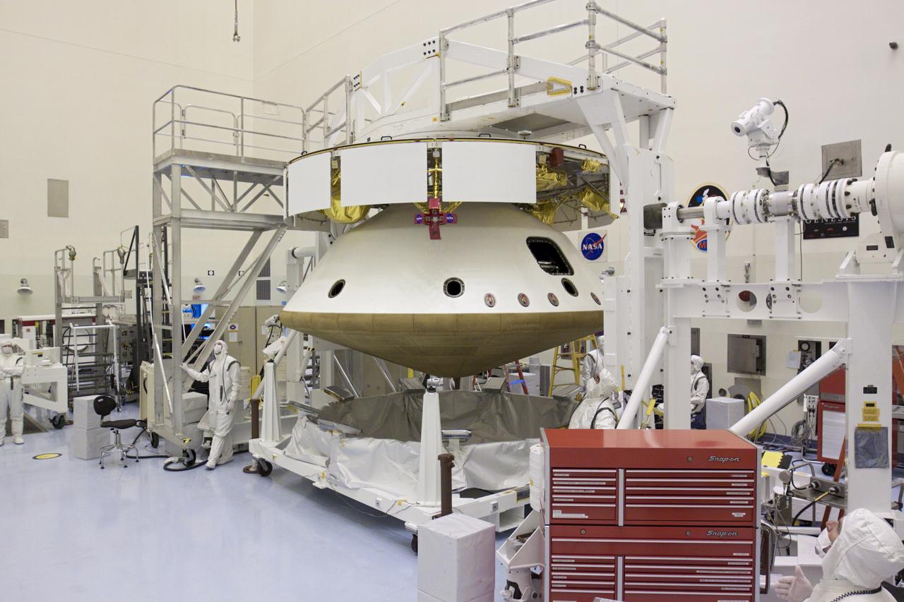 CAPE CANAVERAL, Fla. – In the Payload Hazardous Servicing Facility at NASA’s Kennedy Space Center in Florida, technicians observe the raising of an overhead crane. The crane was used to integrate the heat shield with NASA's Mars Science Laboratory (MSL) mission aeroshell, (containing the compact car-sized rover Curiosity). Earlier, the aeroshell was mated to the cruise stage, which provides solar power, thrusters for navigation, and heat exchangers to the rover during its flight from Earth to Mars. The rover Curiosity has 10 science instruments designed to search for evidence on whether Mars has had environments favorable to microbial life, including chemical ingredients for life. The unique rover will use a laser to look inside rocks and release its gasses so that the rover’s spectrometer can analyze and send the data back to Earth. Launch of MSL aboard a United Launch Alliance Atlas V rocket is scheduled for Nov. 25 from Space Launch Complex 41 on Cape Canaveral Air Force Station in Florida. For more information, visit http:__www.nasa.gov_msl. Photo credit: NASA_Glenn Benson