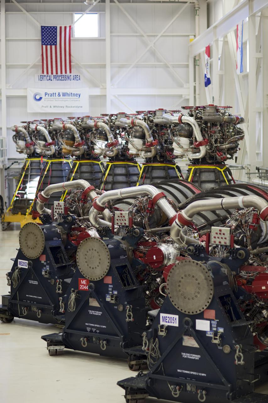 CAPE CANAVERAL, Fla. – At NASA’s Kennedy Space Center in Florida, three Pratt Whitney Rocketdyne space shuttle main engines (SSMEs) sit on stands inside the Engine Shop, with six more engines lined up behind them.    For the first time, all 15 main engines are in the Engine Shop at the same time. They are being prepared for shipment to NASA's Stennis Space Center in Mississippi for storage following the completion of the Space Shuttle Program. The engines are being repurposed for use on NASA’s Space Launch System heavy lift rocket. Photo credit: NASA_Dimitri Gerondidakis