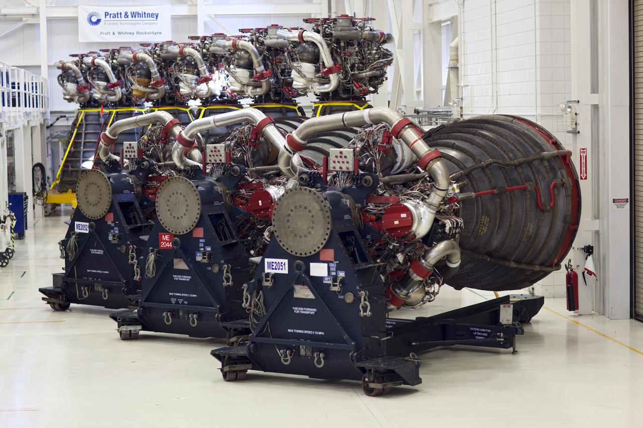 CAPE CANAVERAL, Fla. – At NASA’s Kennedy Space Center in Florida, three Pratt Whitney Rocketdyne space shuttle main engines (SSMEs) sit on stands inside the Engine Shop, with six more engines lined up behind them.    For the first time, all 15 main engines are in the Engine Shop at the same time. They are being prepared for shipment to NASA's Stennis Space Center in Mississippi for storage following the completion of the Space Shuttle Program. The engines are being repurposed for use on NASA’s Space Launch System heavy lift rocket. Photo credit: NASA_Dimitri Gerondidakis