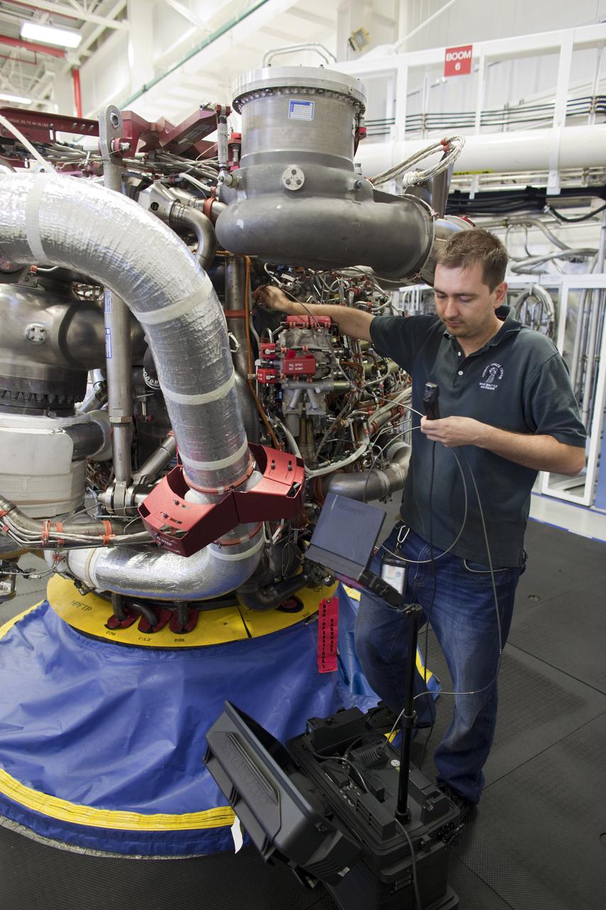 CAPE CANAVERAL, Fla. – Inside the Engine Shop at NASA’s Kennedy Space Center in Florida, a technician performs a boroscope test on a high pressure oxidizer pump on one of the Pratt Whitney Rocketdyne space shuttle main engines (SSMEs) positioned in a test cell.    For the first time, all 15 main engines are in the Engine Shop at the same time. They are being prepared for shipment to NASA's Stennis Space Center in Mississippi for storage following the completion of the Space Shuttle Program. The engines are being repurposed for use on NASA’s Space Launch System heavy lift rocket. Photo credit: NASA_Dimitri Gerondidakis