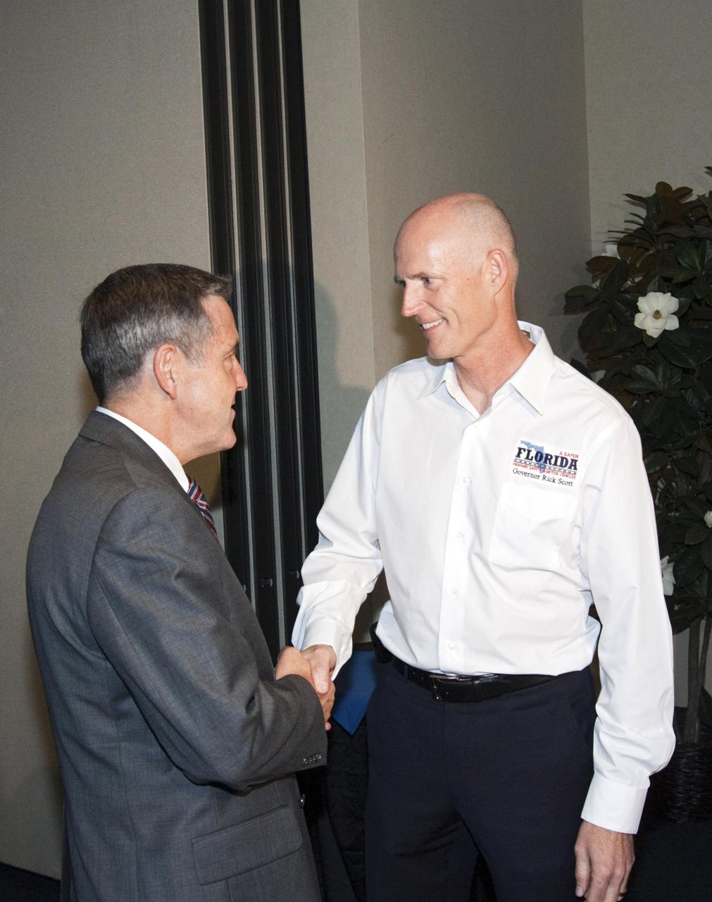 CAPE CANAVERAL, Fla. – Robert Cabana, left, NASA Kennedy Space Center director, greets Florida Governor Rick Scott at the Kennedy Space Center Visitor Complex, Fla., on Oct. 18, before a meeting of the Florida Cabinet. The Cabinet recognized the center's accomplishments in spaceflight and technological innovation during its meeting. Photo credit: NASA_Jim Grossmann