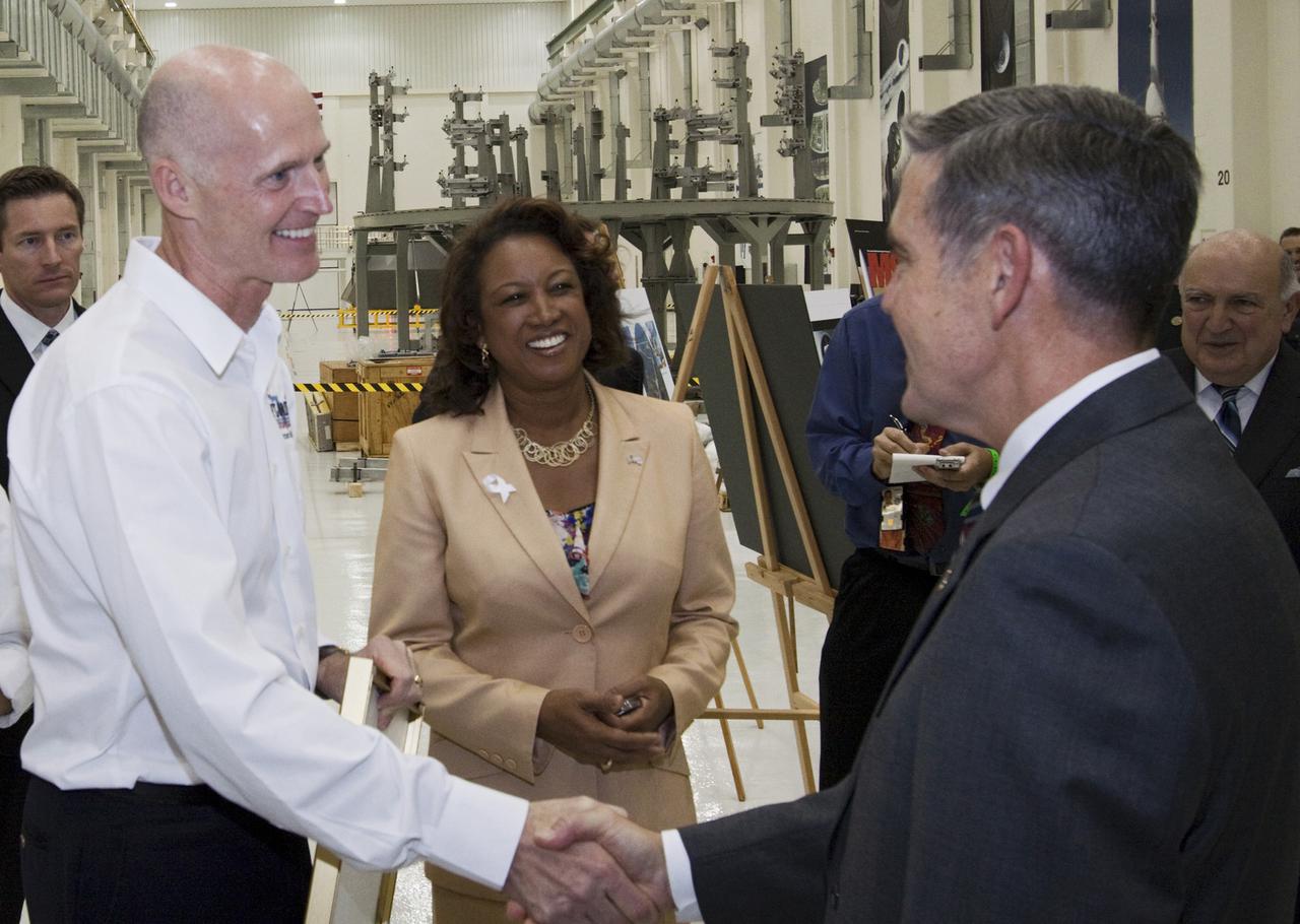 CAPE CANAVERAL, Fla. – In the Operations and Checkout Building at NASA's Kennedy Space Center in Florida, Robert Cabana, Kennedy Space Center director, (right), shakes hands with Florida Gov. Rick Scott, (left), following a tour of the Orion Multi-Purpose Crew Vehicle processing facility. In the center is Florida Lt. Gov. Jennifer Carroll, chairwoman of Space Florida.  The governor and other state officials were at Kennedy for a Florida cabinet meeting and a space industry roundtable at the Kennedy Space Center Visitor Complex’s Debus Conference Center. They also toured selected facilities around the center. Photo credit: NASA_Jim Grossmann