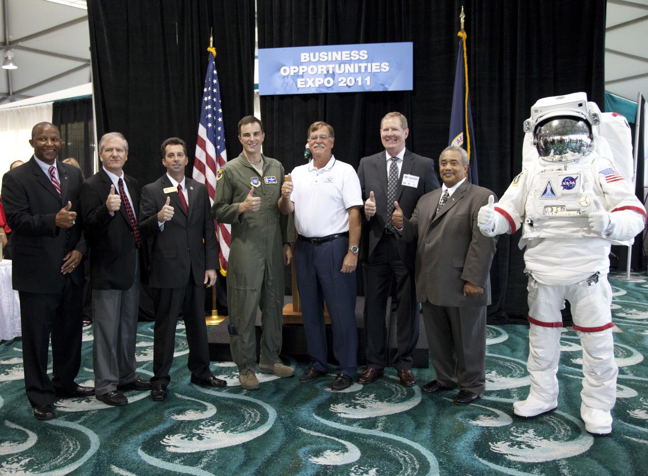 CAPE CANAVERAL, Fla. – Giving a thumbs up during the opening ceremony of the annual Business Opportunities Expo 2011, in Cruise Terminal 4 at Port Canaveral in Florida are, from left, Kelvin Manning, NASA Kennedy Space Center’s associate director for Business Operations; Larry Third, small business specialist at Kennedy Space Center; Patrick D. Gavin, director of community relations for Congressman Bill Posey; Col. Rory D. Welch, vice commander for the U.S. Air Force 45th Space Wing at Patrick Air Force Base; Tom Weinberg, Canaveral Port Authority commissioner; Stephen 'Smokey' Stover, IMCS deputy program manager; Glenn A. Delgado, NASA associate administrator of the Office of Small Business Programs; and the Kennedy Space Center Visitor Complex “Space Man.”    The event is free and open to the public. It features about 175 business and government exhibitors from across the nation and Brevard County and is geared toward business leaders who are interested in learning more about government contracting and what local and national vendors have to offer.  Photo credit: NASA_Gianni Woods