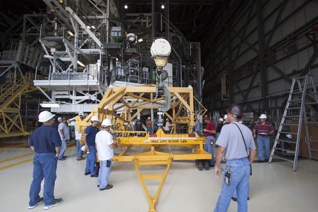CAPE CANAVERAL, Fla. – Inside Orbiter Processing Facility-2 at NASA’s Kennedy Space Center in Florida, technicians start to position a crane and support equipment near space shuttle Atlantis in preparation for removal of the left orbital maneuvering system (OMS) pod.   The work is part of the Space Shuttle Program’s transition and retirement processing of shuttle Atlantis. The OMS pods will be sent to White Sands Space Harbor in New Mexico where they will undergo a complete deservicing and cleaning and then be returned to Kennedy for reinstallation on Atlantis.  Atlantis is being prepared for display at the Kennedy Space Center Visitor Complex in Florida.  Photo credit: NASA_Jim Grossmann