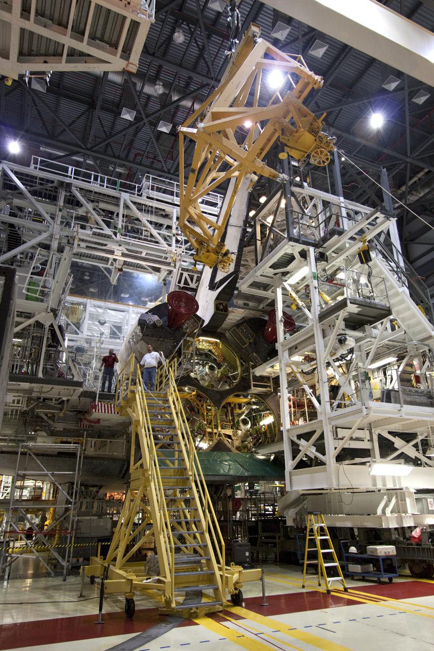 CAPE CANAVERAL, Fla. – Inside Orbiter Processing Facility-2 at NASA’s Kennedy Space Center in Florida, technicians monitor the progress as a large crane and support equipment are lifted high and moved toward space shuttle Atlantis to aid in removal of the left orbital maneuvering system (OMS) pod.   The work is part of the Space Shuttle Program’s transition and retirement processing of shuttle Atlantis. The OMS pods will be sent to White Sands Space Harbor in New Mexico where they will undergo a complete deservicing and cleaning and then be returned to Kennedy for reinstallation on Atlantis.  Atlantis is being prepared for display at the Kennedy Space Center Visitor Complex in Florida.  Photo credit: NASA_Jim Grossmann