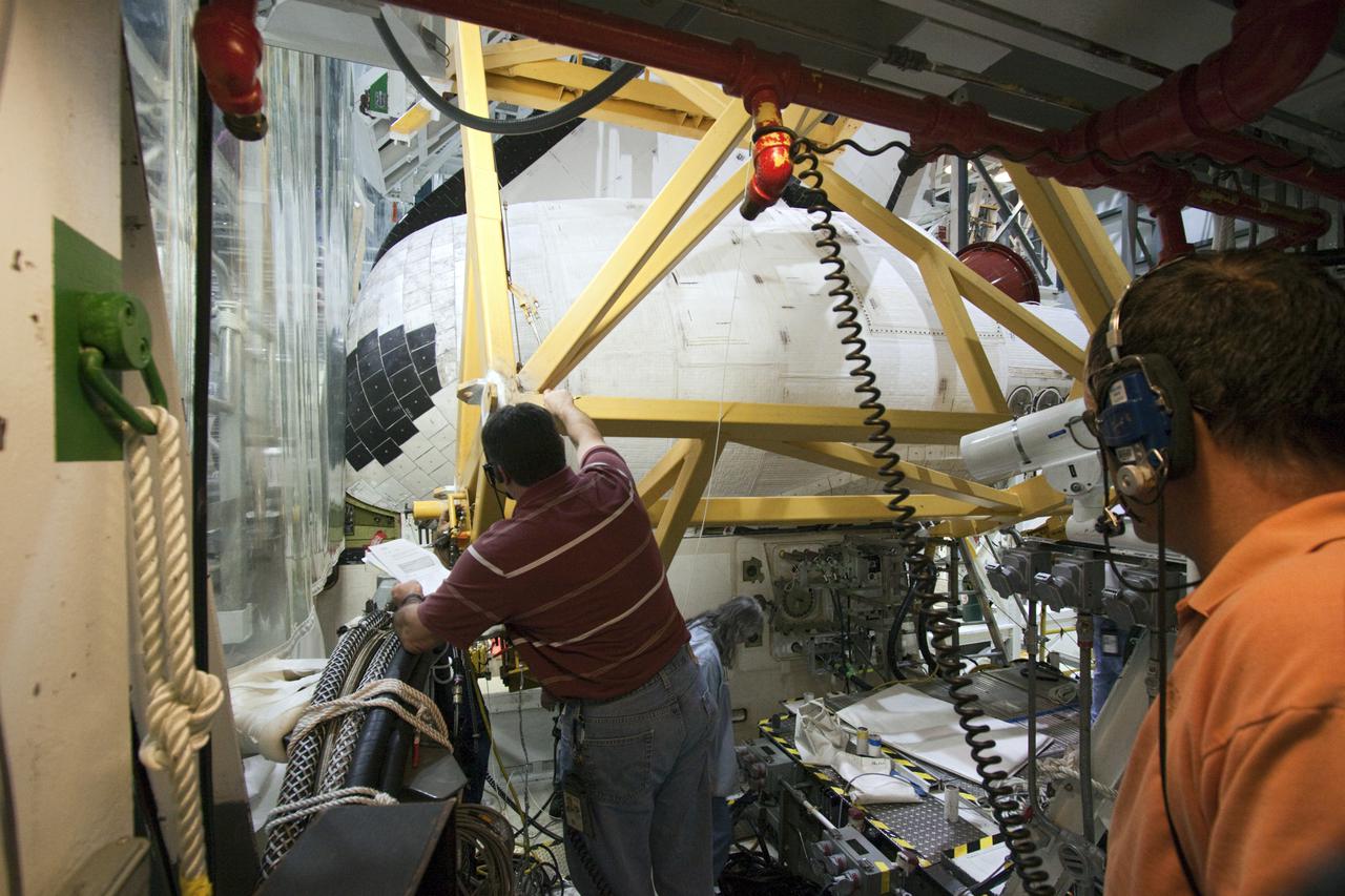 CAPE CANAVERAL, Fla. – Inside Orbiter Processing Facility-2 at NASA’s Kennedy Space Center in Florida, technicians position lifting equipment around space shuttle Atlantis’ left orbital maneuvering system (OMS) pod in order to remove it.   The work is part of the Space Shuttle Program’s transition and retirement processing of shuttle Atlantis. The OMS pods will be sent to White Sands Space Harbor in New Mexico where they will undergo a complete deservicing and cleaning and then be returned to Kennedy for reinstallation on Atlantis.  Atlantis is being prepared for display at the Kennedy Space Center Visitor Complex in Florida.  Photo credit: NASA_Jim Grossmann