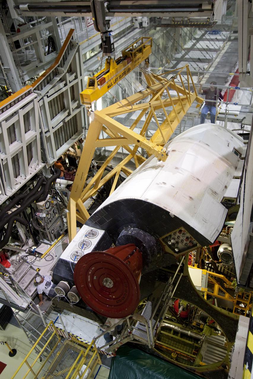 CAPE CANAVERAL, Fla. – Inside Orbiter Processing Facility-2 at NASA’s Kennedy Space Center in Florida, a large crane with support equipment begins to remove space shuttle Atlantis’ left orbital maneuvering system (OMS) pod.  The work is part of the Space Shuttle Program’s transition and retirement processing of shuttle Atlantis. The OMS pods will be sent to White Sands Space Harbor in New Mexico where they will undergo a complete deservicing and cleaning and then be returned to Kennedy for reinstallation on Atlantis.  Atlantis is being prepared for display at the Kennedy Space Center Visitor Complex in Florida.  Photo credit: NASA_Jim Grossmann