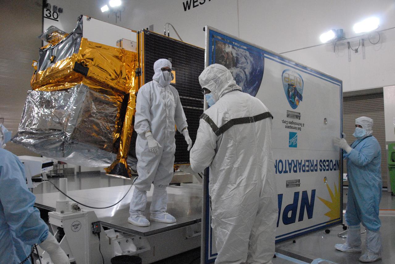 In a clean room inside the Astrotech Payload Processing Facility at Vandenberg Air Force Base in California, Ball Aerospace technicians close out NASA’s National Polar-orbiting Operational Environmental Satellite System Preparatory Project (NPP) before preparing it for transport to the launch pad.     NPP represents a critical first step in building the next-generation of Earth-observing satellites. NPP will carry the first of the new sensors developed for this satellite fleet, now known as the Joint Polar Satellite System (JPSS), to be launched in 2016. NPP is the bridge between NASA's Earth Observing System (EOS) satellites and the forthcoming series of JPSS satellites. The mission will test key technologies and instruments for the JPSS missions. NPP is targeted to launch Oct. 28 from Space Launch Complex-2 aboard a United Launch Alliance Delta II rocket. For more information, visit http:__www.nasa.gov_NPP.  Photo credit: NASA_Dan Kokoska, VAFB