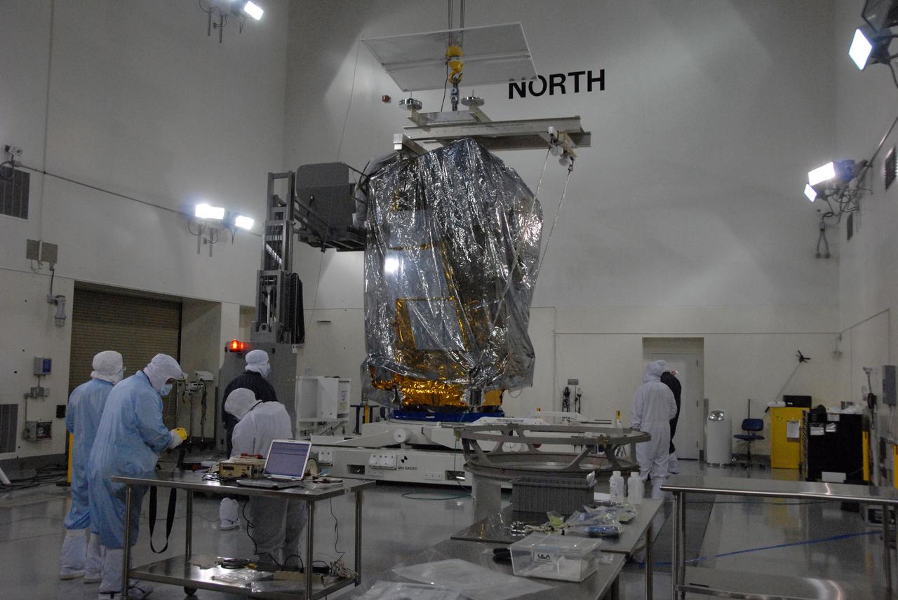In a clean room inside the Astrotech Payload Processing Facility at Vandenberg Air Force Base in California, Ball Aerospace technicians prepare to attach NASA’s National Polar-orbiting Operational Environmental Satellite System Preparatory Project (NPP) spacecraft to a payload adapter. NPP represents a critical first step in building the next-generation of Earth-observing satellites. NPP will carry the first of the new sensors developed for this satellite fleet, now known as the Joint Polar Satellite System (JPSS), to be launched in 2016. NPP is the bridge between NASA's Earth Observing System (EOS) satellites and the forthcoming series of JPSS satellites. The mission will test key technologies and instruments for the JPSS missions. NPP is targeted to launch Oct. 28 from Space Launch Complex-2 aboard a United Launch Alliance Delta II rocket. For more information, visit http:__www.nasa.gov_NPP. Photo credit: NASA_Roy Allison, VAFB