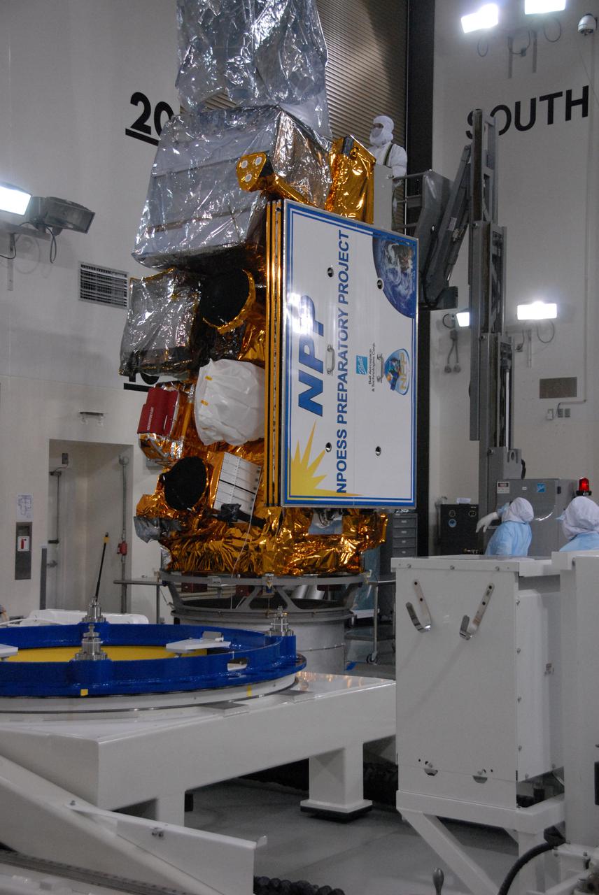 In a clean room inside the Astrotech Payload Processing Facility at Vandenberg Air Force Base in California, Ball Aerospace technicians attach NASA’s National Polar-orbiting Operational Environmental Satellite System Preparatory Project (NPP) spacecraft to a payload adapter. NPP represents a critical first step in building the next-generation of Earth-observing satellites. NPP will carry the first of the new sensors developed for this satellite fleet, now known as the Joint Polar Satellite System (JPSS), to be launched in 2016. NPP is the bridge between NASA's Earth Observing System (EOS) satellites and the forthcoming series of JPSS satellites. The mission will test key technologies and instruments for the JPSS missions. NPP is targeted to launch Oct. 28 from Space Launch Complex-2 aboard a United Launch Alliance Delta II rocket. For more information, visit http:__www.nasa.gov_NPP. Photo credit: NASA_Roy Allison, VAFB
