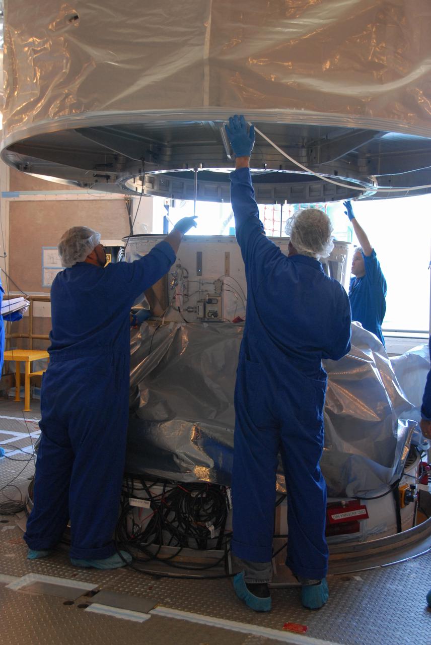 Workers atop Vandenberg Air Force Base's Space Launch Complex-2 prepare to secure the payload transportation canister containing NASA’s National Polar-orbiting Operational Environmental Satellite System Preparatory Project (NPP) spacecraft.   NPP represents a critical first step in building the next-generation of Earth-observing satellites. NPP will carry the first of the new sensors developed for this satellite fleet, now known as the Joint Polar Satellite System (JPSS), to be launched in 2016. NPP is the bridge between NASA's Earth Observing System (EOS) satellites and the forthcoming series of JPSS satellites. The mission will test key technologies and instruments for the JPSS missions. NPP is targeted to launch Oct. 28 from Space Launch Complex-2 aboard a United Launch Alliance Delta II rocket. For more information, visit http:__www.nasa.gov_NPP.  Photo credit: NASA_Mark P. Mackley, VAFB