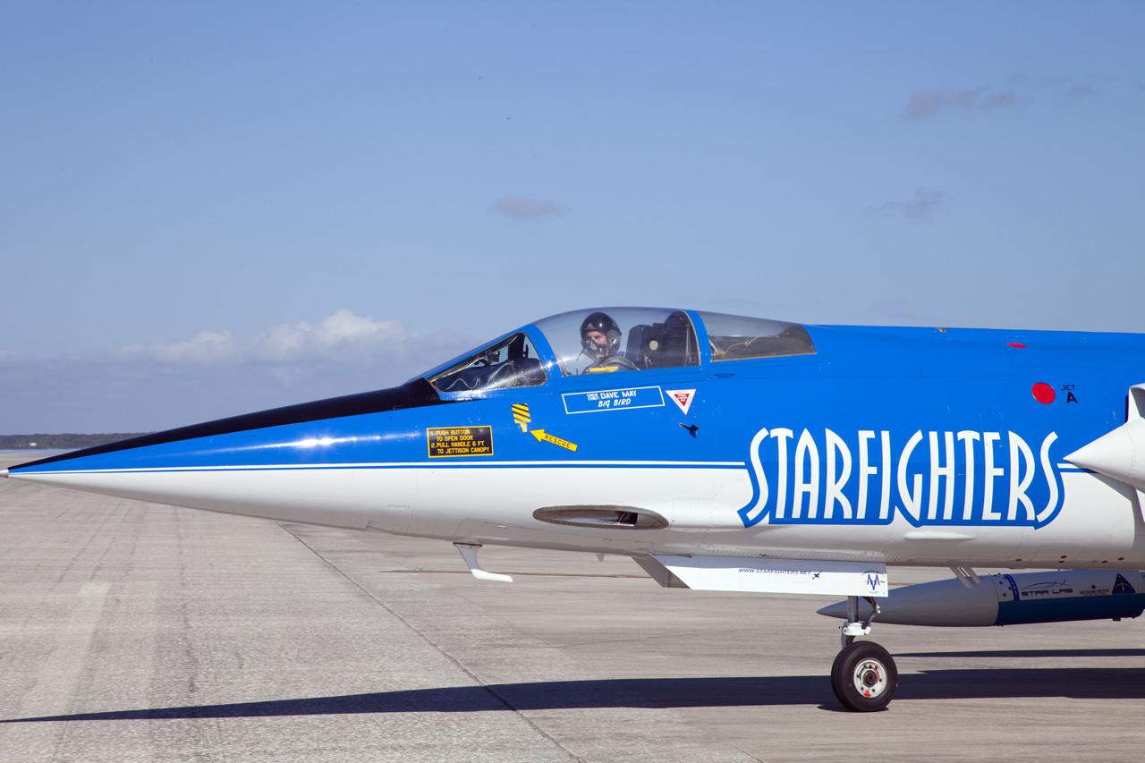 CAPE CANAVERAL, Fla. – Pilot Rick Svetkoff sits in the cockpit of a Starfighters, Inc. F-104 supersonic jet before conducting a high speed taxi test on the runway at the Shuttle Landing Facility (SLF) at NASA’s Kennedy Space Center in Florida. The Star Lab suborbital launch vehicle developed by 4Frontiers Corporation can be seen above the front wheel.  4Frontiers is testing the Star Lab suborbital launch vehicle which has the potential to carry payloads into low earth orbit. Tests are being conducted to verify the aeronautical conditions of the Star Lab suborbital launch vehicle. This is the first of eight tests the launch vehicle will undergo. 4Frontiers Corporation is aiming for testing to be completed by early 2012, with commercial flights starting mid-2012. Starfighters, Inc. has signed a Space Act Agreement with NASA for the use of the SLF facilities at Kennedy Space Center. Photo credit: NASA_Gianni M. Woods