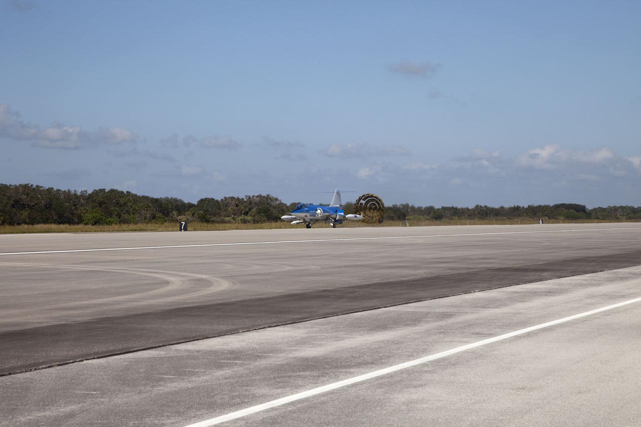 CAPE CANAVERAL, Fla. – On the runway at the Shuttle Landing Facility (SLF) at NASA’s Kennedy Space Center in Florida, the parachute on a Starfighters, Inc. F-104 supersonic jet, piloted by Rick Svetkoff, deploys after conducting a high speed taxi test. Hidden from the camera on the right side of the jet is the Star Lab suborbital launch vehicle developed by 4Frontiers Corporation.  4Frontiers is testing the Star Lab suborbital launch vehicle which has the potential to carry payloads into low earth orbit. Tests are being conducted to verify the aeronautical conditions of the Star Lab suborbital launch vehicle. This is the first of eight tests the launch vehicle will undergo. 4Frontiers Corporation is aiming for testing to be completed by early 2012, with commercial flights starting mid-2012. Starfighters, Inc. has signed a Space Act Agreement with NASA for the use of the SLF facilities at Kennedy Space Center. Photo credit: NASA_Gianni M. Woods