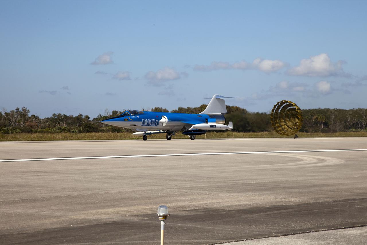 CAPE CANAVERAL, Fla. – On the runway at the Shuttle Landing Facility (SLF) at NASA’s Kennedy Space Center in Florida, the parachute on a Starfighters, Inc. F-104 supersonic jet, piloted by Rick Svetkoff, deploys after conducting a high speed taxi test. The Star Lab suborbital launch vehicle developed by 4Frontiers Corporation can be seen just above the front wheel.  4Frontiers is testing the Star Lab suborbital launch vehicle which has the potential to carry payloads into low earth orbit. Tests are being conducted to verify the aeronautical conditions of the Star Lab suborbital launch vehicle. This is the first of eight tests the launch vehicle will undergo. 4Frontiers Corporation is aiming for testing to be completed by early 2012, with commercial flights starting mid-2012. Starfighters, Inc. has signed a Space Act Agreement with NASA for the use of the SLF facilities at Kennedy Space Center. Photo credit: NASA_Gianni M. Woods