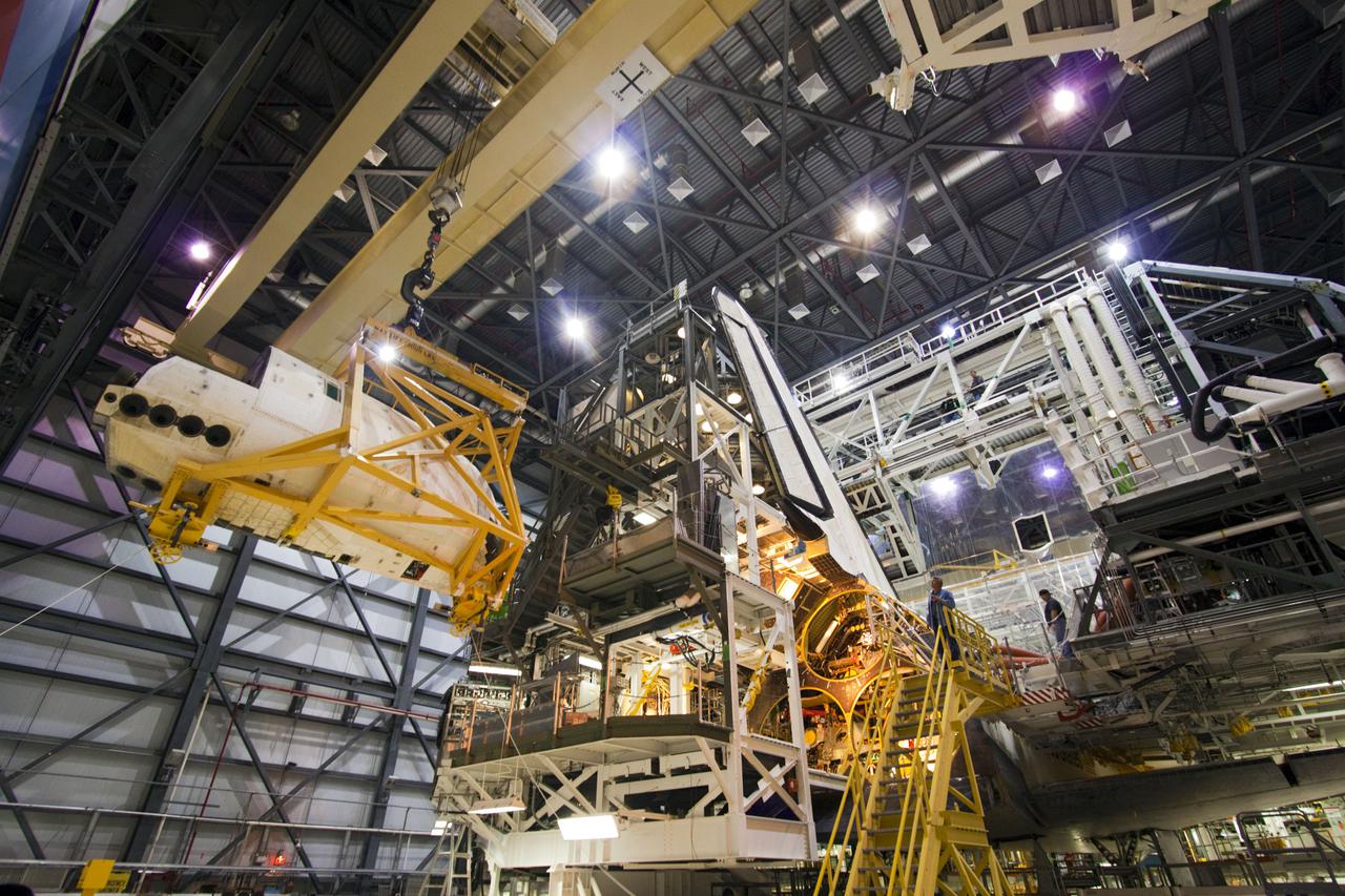 CAPE CANAVERAL, Fla. – Inside Orbiter Processing Facility-1 at NASA’s Kennedy Space Center in Florida, a crane is used to lift a sling holding one of two orbital maneuvering system (OMS) pods that will be re-installed on space shuttle Discovery.   The OMS pods were returned from White Sands Space Harbor in New Mexico where they underwent a complete deservicing and cleaning. The work is part of the Space Shuttle Program’s transition and retirement processing of shuttle Discovery. Discovery is being prepared for display at Smithsonian’s National Air and Space Museum, Steven F. Udvar-Hazy Center in Chantilly, Va. For more information, visit http:__www.nasa.gov_shuttle.  Photo credit: NASA_Jim Grossmann