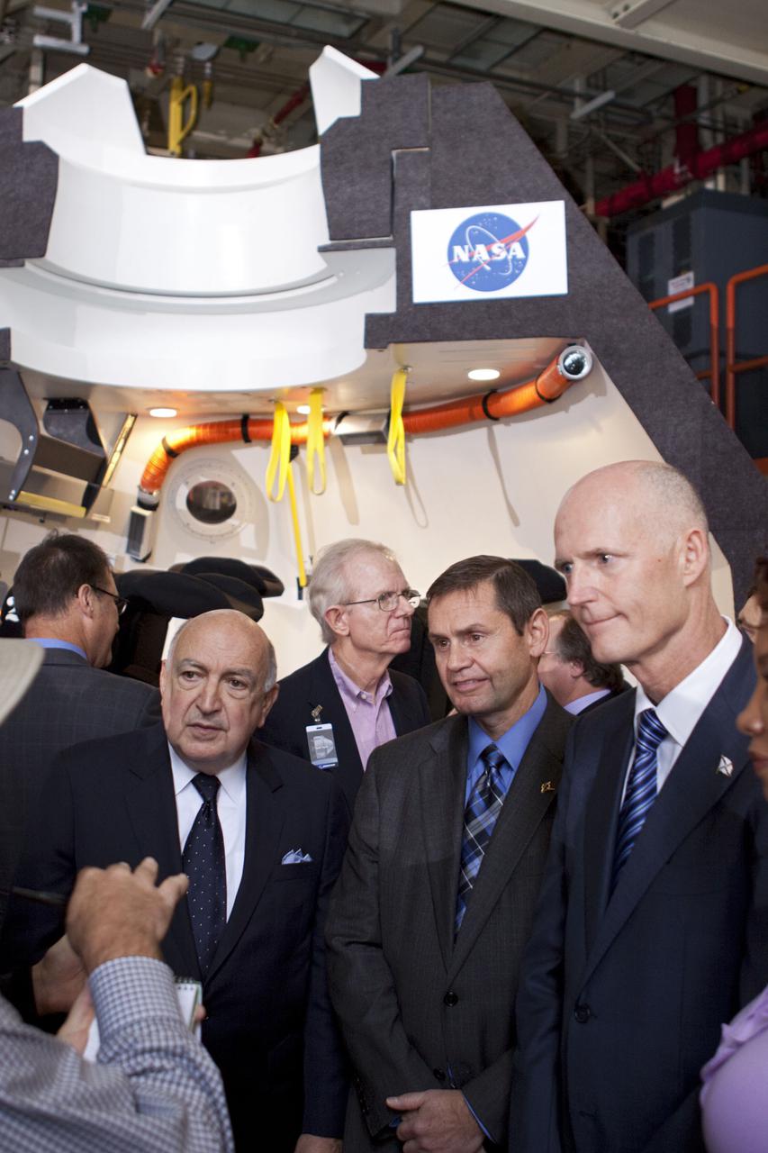 CAPE CANAVERAL, Fla. – In the Orbiter Processing Facility-3 (OPF-3) at NASA’s Kennedy Space Center in Florida, from left, Frank DiBello, president of Space Florida, John Elbon, vice president and general manager of Boeing's Space Exploration, and Florida Gov. Rick Scott, speak to media before a full-scale mockup of The Boeing Company’s CST-100 spacecraft at the ceremony announcing the signing of an innovative agreement between NASA and Space Florida.  NASA announced a partnership with Space Florida to occupy, use and modify Kennedy Space Center's Orbiter Processing Facility-3 (OPF-3), the Space Shuttle Main Engine Processing Facility and Processing Control Center. Space Florida has an agreement for use of the OPF-3 with the Boeing Company to manufacture and test the company's Crew Space Transportation (CST-100) spacecraft. The 15-year use permit deal is the latest step Kennedy is making as the center transitions from a historically government-only launch complex to a multi-user spaceport. For more information, visit http:__www.nasa.gov_exploration_commercial_index.html. Photo credit: NASA_Kim Shiflett