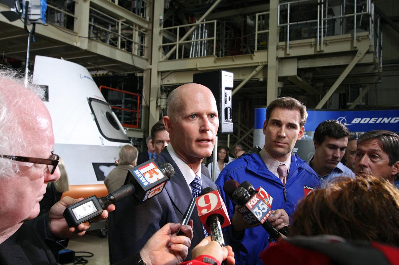 CAPE CANAVERAL, Fla. – In the Orbiter Processing Facility-3 (OPF-3) at NASA’s Kennedy Space Center in Florida, Florida Gov. Rick Scott speaks to the media after the ceremony which announced the signing of an innovative agreement between NASA and Space Florida.  In the background is a full-scale mockup of The Boeing Company’s CST-100 spacecraft.  NASA announced a partnership with Space Florida to occupy, use and modify Kennedy Space Center's Orbiter Processing Facility-3 (OPF-3), the Space Shuttle Main Engine Processing Facility and Processing Control Center. Space Florida has an agreement for use of the OPF-3 with the Boeing Company to manufacture and test the company's Crew Space Transportation (CST-100) spacecraft. The 15-year use permit deal is the latest step Kennedy is making as the center transitions from a historically government-only launch complex to a multi-user spaceport. For more information, visit http:__www.nasa.gov_exploration_commercial_index.html. Photo credit: NASA_Ken Thornsley