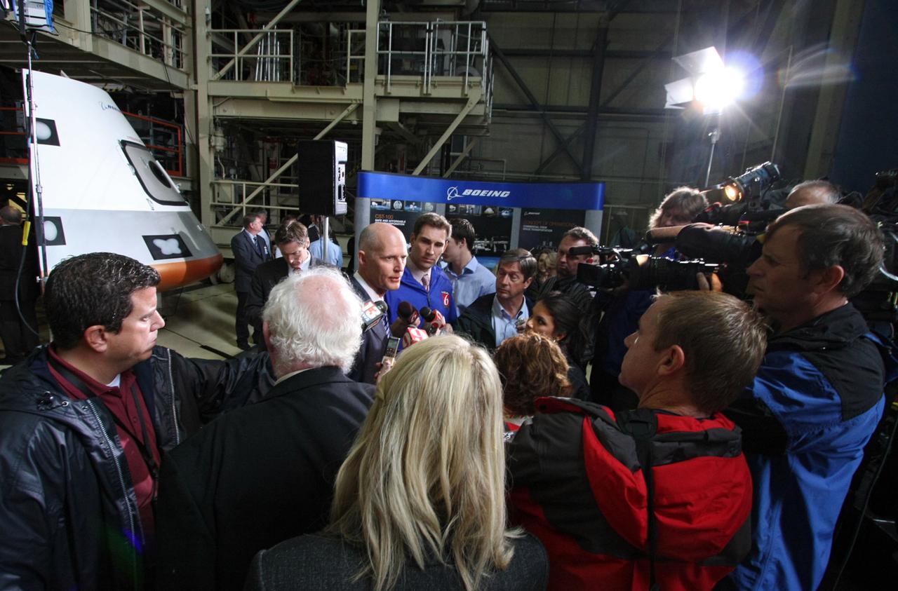 CAPE CANAVERAL, Fla. – In the Orbiter Processing Facility-3 (OPF-3) at NASA’s Kennedy Space Center in Florida, Florida Gov. Rick Scott speaks to the media after the ceremony which announced the signing of an innovative agreement between NASA and Space Florida.  In the background is a full-scale mockup of The Boeing Company’s CST-100 spacecraft.  NASA announced a partnership with Space Florida to occupy, use and modify Kennedy Space Center's Orbiter Processing Facility-3 (OPF-3), the Space Shuttle Main Engine Processing Facility and Processing Control Center. Space Florida has an agreement for use of the OPF-3 with the Boeing Company to manufacture and test the company's Crew Space Transportation (CST-100) spacecraft. The 15-year use permit deal is the latest step Kennedy is making as the center transitions from a historically government-only launch complex to a multi-user spaceport. For more information, visit http:__www.nasa.gov_exploration_commercial_index.html. Photo credit: NASA_Ken Thornsley