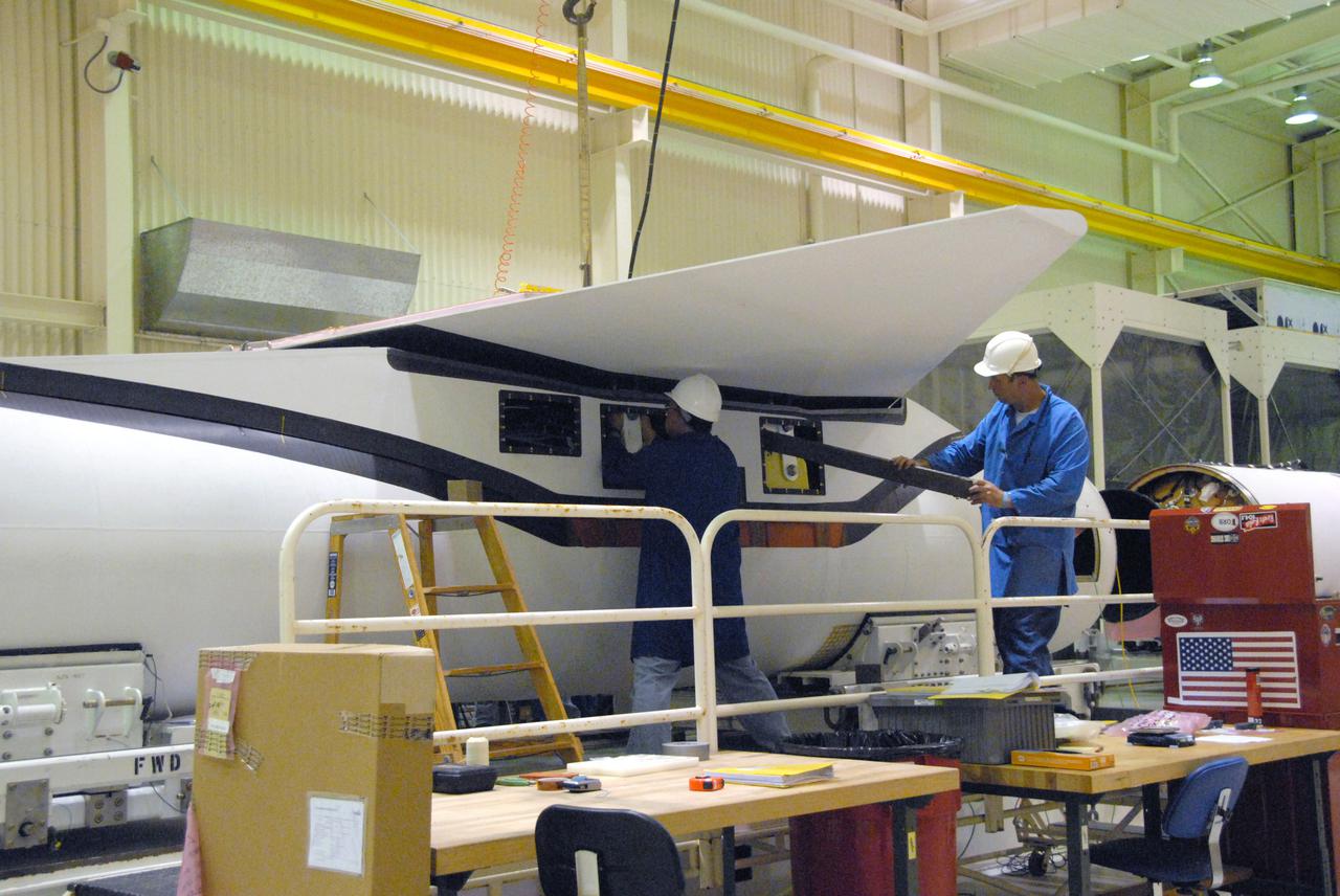 VANDENBERG AIR FORCE BASE, Calif. -- In a processing facility at Vandenberg Air Force Base in California, technicians complete final installation of the wing on the Pegasus XL launch vehicle. The Orbital Sciences Corp. Pegasus rocket will launch the Nuclear Spectroscopic Telescope Array (NuSTAR) into space.     After the rocket and spacecraft are processed at Vandenberg, they will be flown on the Orbital Sciences’ L-1011 carrier aircraft to the Ronald Reagan Ballistic Missile Defense Test Site at the Pacific Ocean’s Kwajalein Atoll for launch. The high-energy x-ray telescope will conduct a census for black holes, map radioactive material in young supernovae remnants, and study the origins of cosmic rays and the extreme physics around collapsed stars. For more information, visit science.nasa.gov_missions_nustar_.  Photo credit: NASA_Randy Beaudoin, VAFB