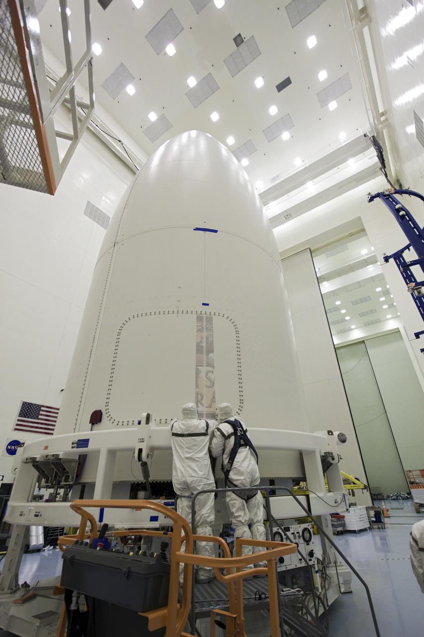 CAPE CANAVERAL, Fla. – In the Payload Hazardous Servicing Facility at NASA's Kennedy Space Center in Florida, technicians apply the first section of Mars Science Laboratory (MSL) mission logo to the exterior of an Atlas V rocket's payload fairing. Tucked inside the fairing is the MSL spacecraft, including a compact car-sized rover, Curiosity, which has 10 science instruments designed to search for evidence on whether Mars has had environments favorable to microbial life, including the chemical ingredients for life. The unique rover will use a laser to look inside rocks and release its gasses so that the rover’s spectrometer can analyze and send the data back to Earth. Launch of MSL aboard a United Launch Alliance Atlas V rocket is planned for Nov. 25 from Space Launch Complex-41 on Cape Canaveral Air Force Station. For more information, visit http:__www.nasa.gov_msl. Photo credit: NASA_Jim Grossmann