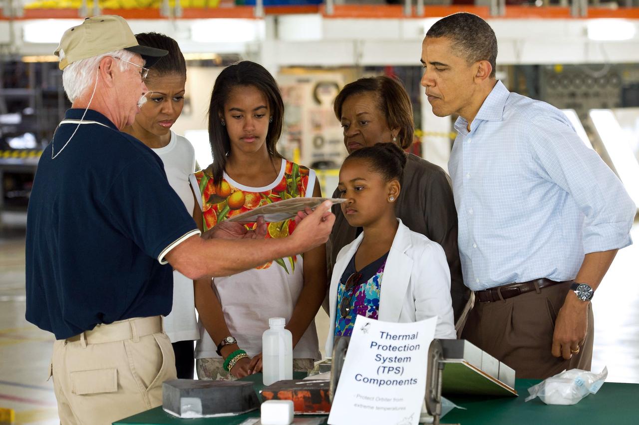 Terry White, United Space Alliance project lead for thermal protection systems, left, shows President Barack Obama and his family, from left, First Lady Michelle Obama, Malia, Marian Robinson and Sasha, how tiles work on the space shuttle during their visit to the Orbital Processing Facility at the NASA Kennedy Space Center in Cape Canaveral, Fla., Friday, April 29, 2011. Photo Credit: (NASA/Bill Ingalls)