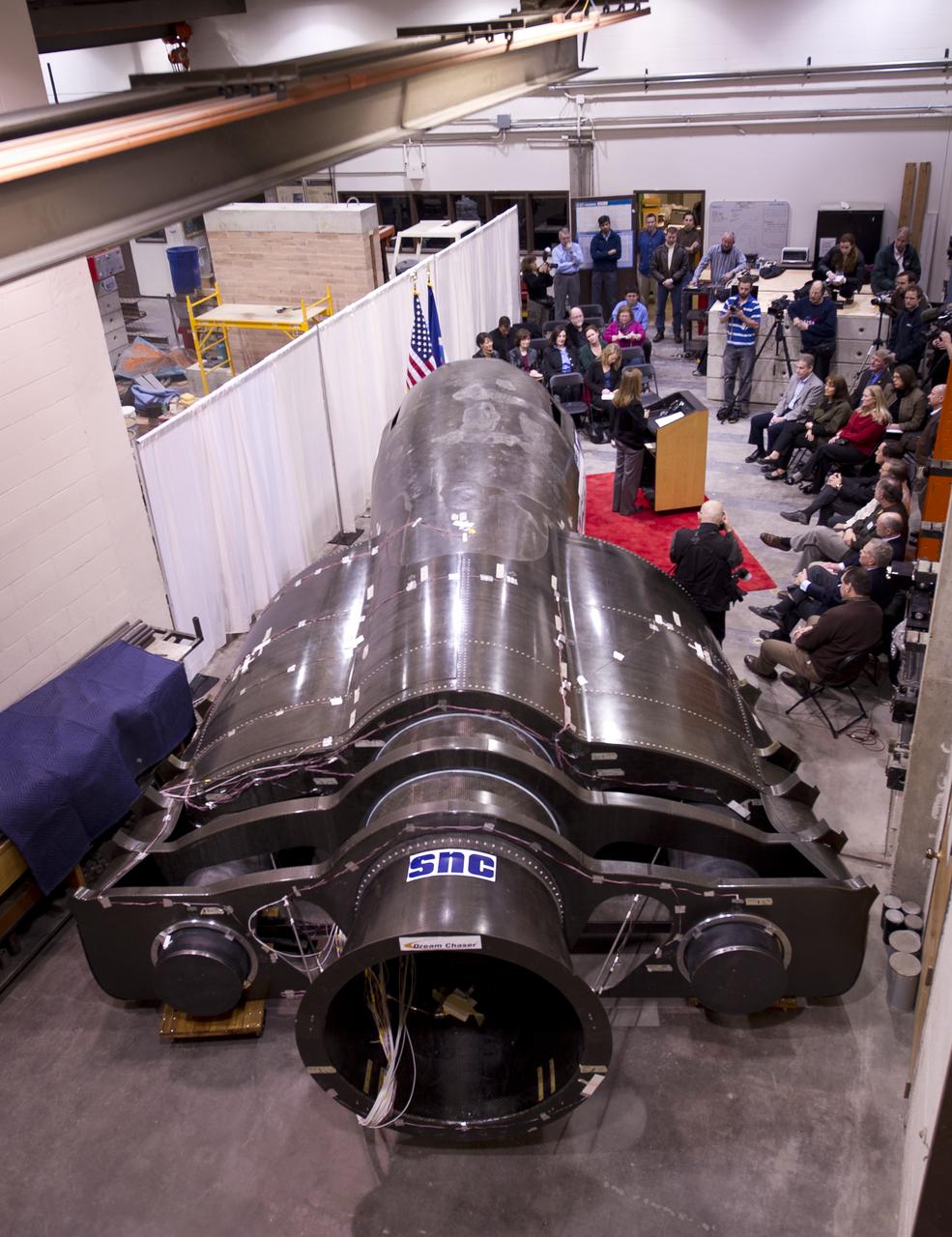 Sierra Nevada's Dream Chaser spacecraft is seen as NASA Deputy Administrator Lori Garver talks during a press conference on Saturday, Feb. 5, 2011, at the University of Colorado at Boulder.  Sierra Nevada's Dream Chaser spacecraft is under development with support from NASA's Commercial Crew Development Program to provide crew transportation to and from low Earth orbit.  NASA is helping private companies develop innovative technologies to ensure that the U.S. remains competitive in future space endeavors. Photo Credit: (NASA/Bill Ingalls)