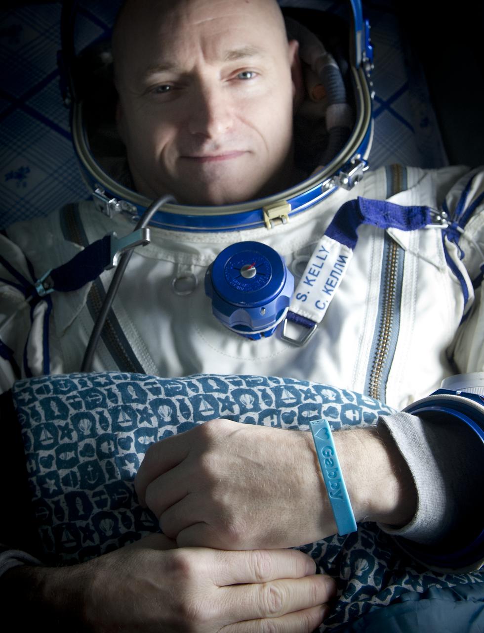 Expedition 26 Commander Scott Kelly wears a blue wrist band that has a peace symbol, a heart and the word "Gabby" to show his love of his sister-in-law U.S. Rep. Gabrielle Giffords as he rest onboard a Russian Search and Rescue helicopter shortly after he and fellow crew members Oleg Skripochka and Alexander Kaleri landed in their Soyuz TMA-01M capsule near the town of Arkalyk, Kazakhstan on Wednesday, March 16, 2011. NASA Astronaut Kelly, Russian Cosmonauts Skripochka and Kaleri are returning from almost six months onboard the International Space Station where they served as members of the Expedition 25 and 26 crews. Photo Credit: (NASA/Bill Ingalls)