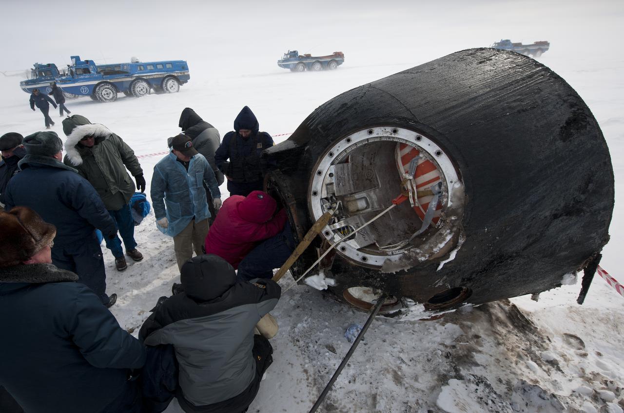 Russian support personnel work to help get crew members out of the Soyuz TMA-01M spacecraft shortly after the capsule landed with Expedition 26 Commander Scott Kelly and Flight Engineers Oleg Skripochka and Alexander Kaleri near the town of Arkalyk, Kazakhstan on Wednesday, March 16, 2011. NASA Astronaut Kelly, Russian Cosmonauts Skripochka and Kaleri are returning from almost six months onboard the International Space Station where they served as members of the Expedition 25 and 26 crews. Photo Credit: (NASA/Bill Ingalls)