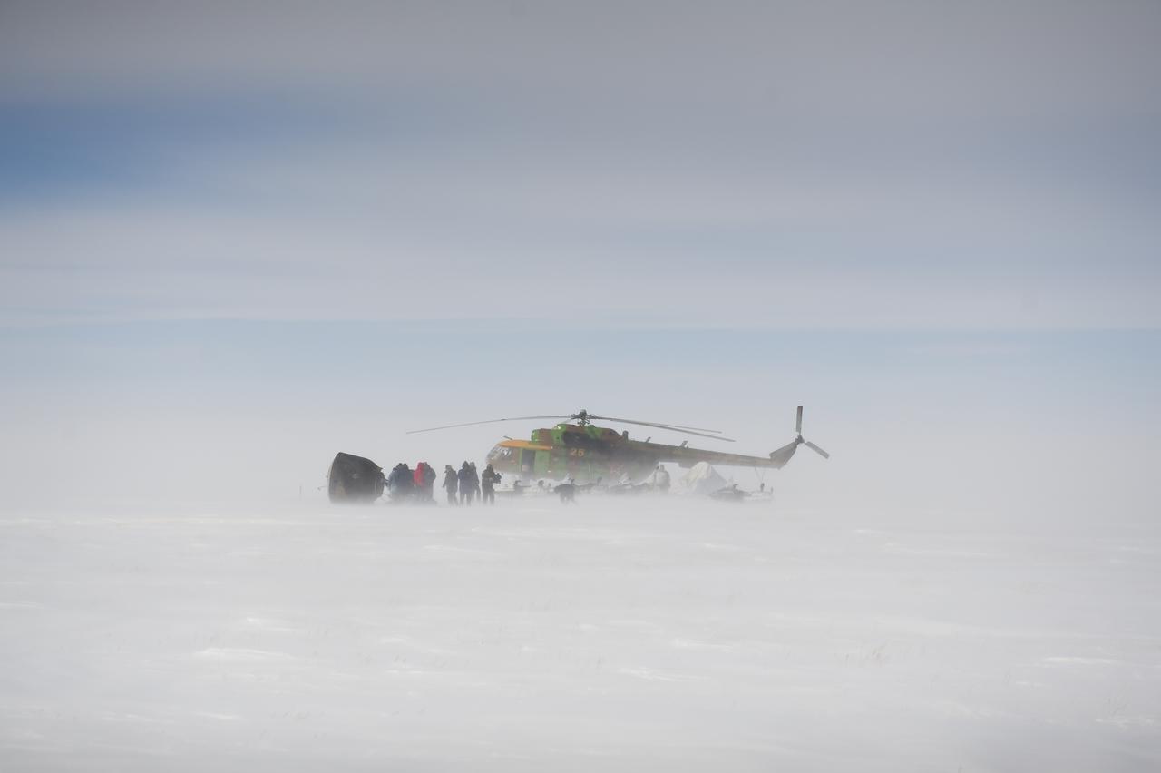Russian support personnel work to help get crew members out of the Soyuz TMA-01M spacecraft shortly after the capsule landed with Expedition 26 Commander Scott Kelly and Flight Engineers Oleg Skripochka and Alexander Kaleri near the town of Arkalyk, Kazakhstan on Wednesday, March 16, 2011. NASA Astronaut Kelly, Russian Cosmonauts Skripochka and Kaleri are returning from almost six months onboard the International Space Station where they served as members of the Expedition 25 and 26 crews. Photo Credit: (NASA/Bill Ingalls)