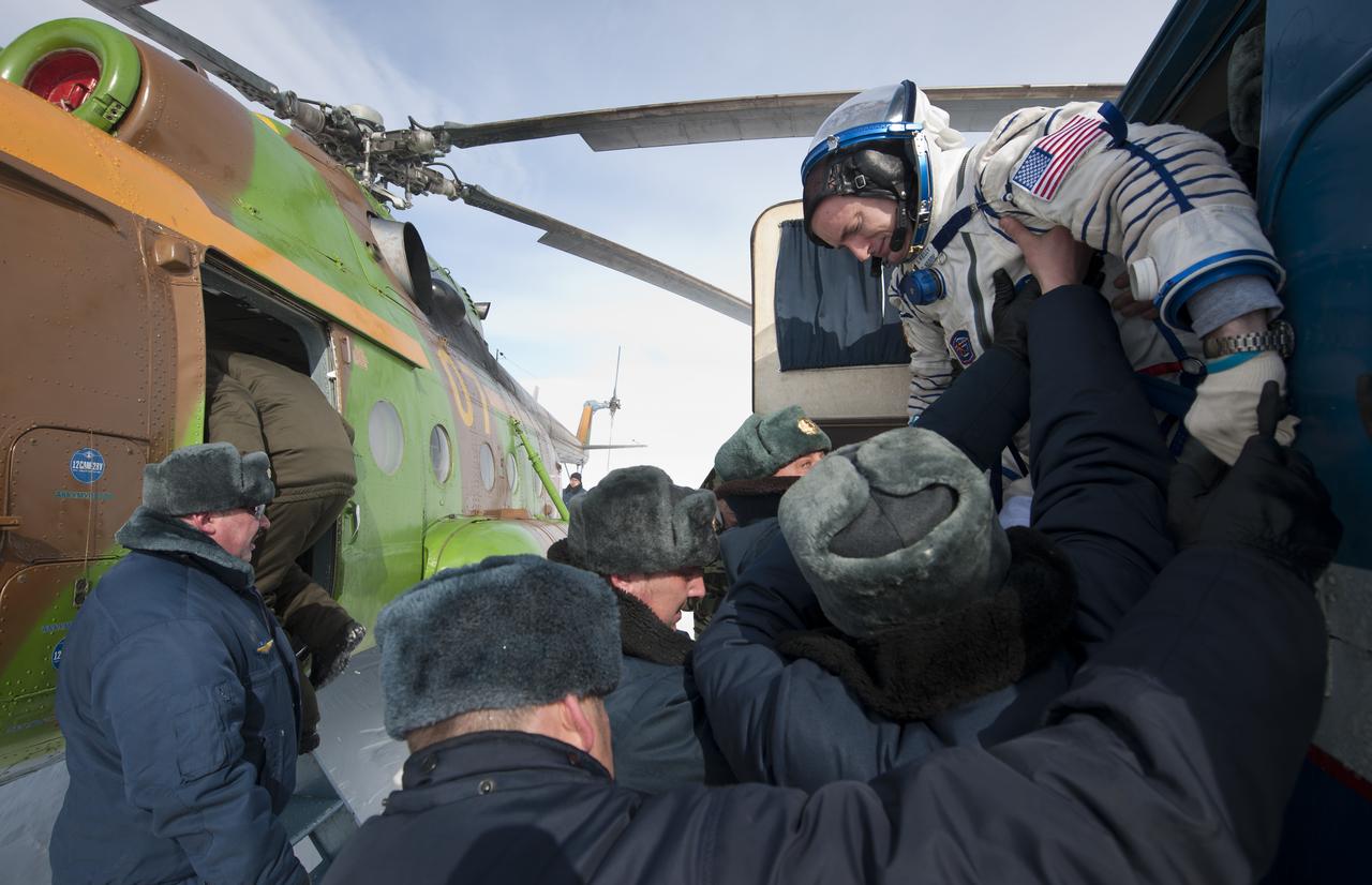 Expedition 26 Commander Scott Kelly is helped as he exits a Russian all terrain vehicle (ATV) that delivered him to a helicopter from the Soyuz TMA-01M spacecraft shortly after the capsule landed with Kelly and Expedition 26 Flight Engineers Oleg Skripochka and Alexander Kaleri near the town of Arkalyk, Kazakhstan on Wednesday, March 16, 2011. NASA Astronaut Kelly, Russian Cosmonauts Skripochka and Kaleri are returning from almost six months onboard the International Space Station where they served as members of the Expedition 25 and 26 crews. Photo Credit: (NASA/Bill Ingalls)